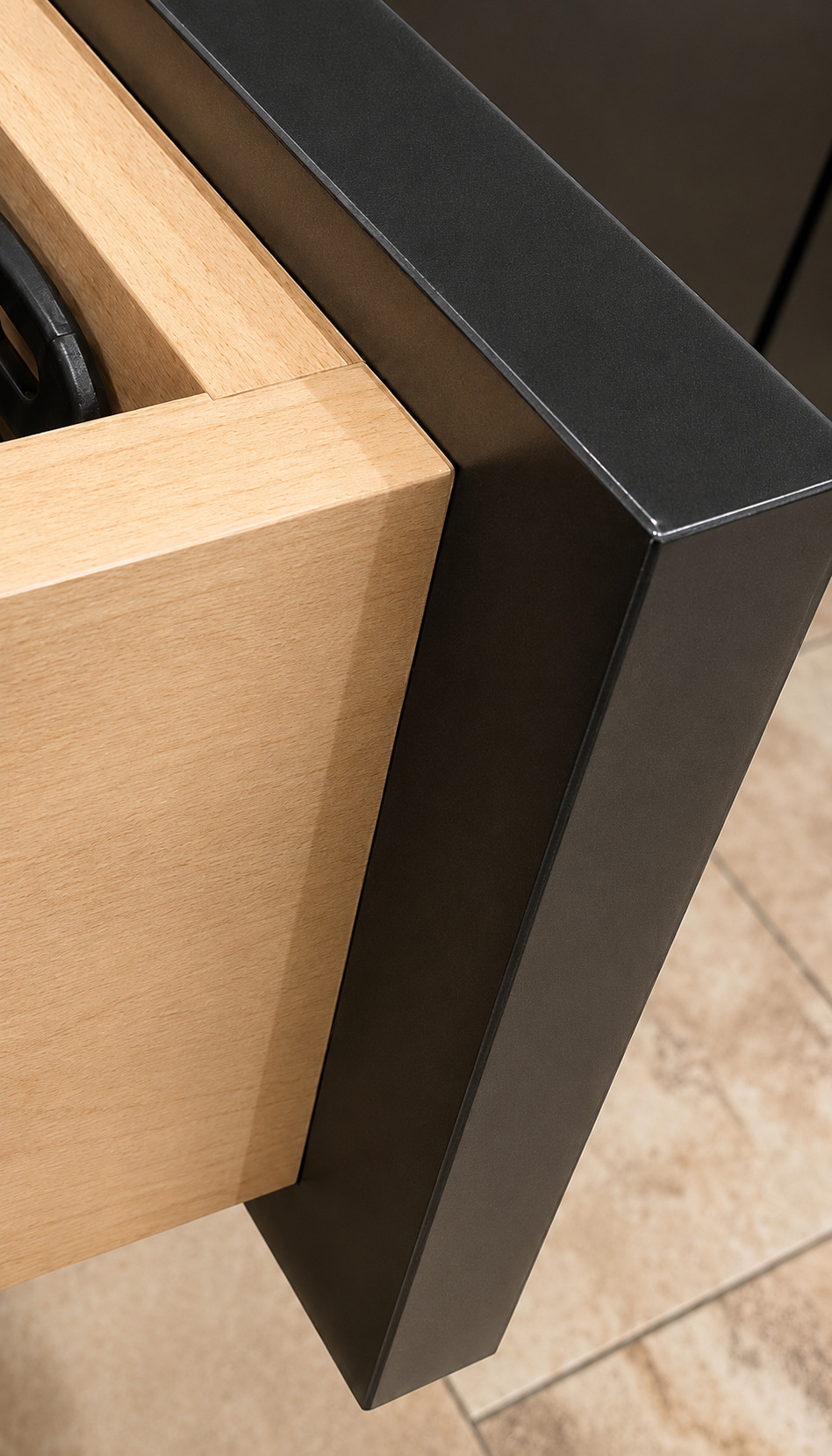 Side view of a dark kitchen island with stools, pendant lights, wood open shelves, range wall, and under-cabinet lighting.