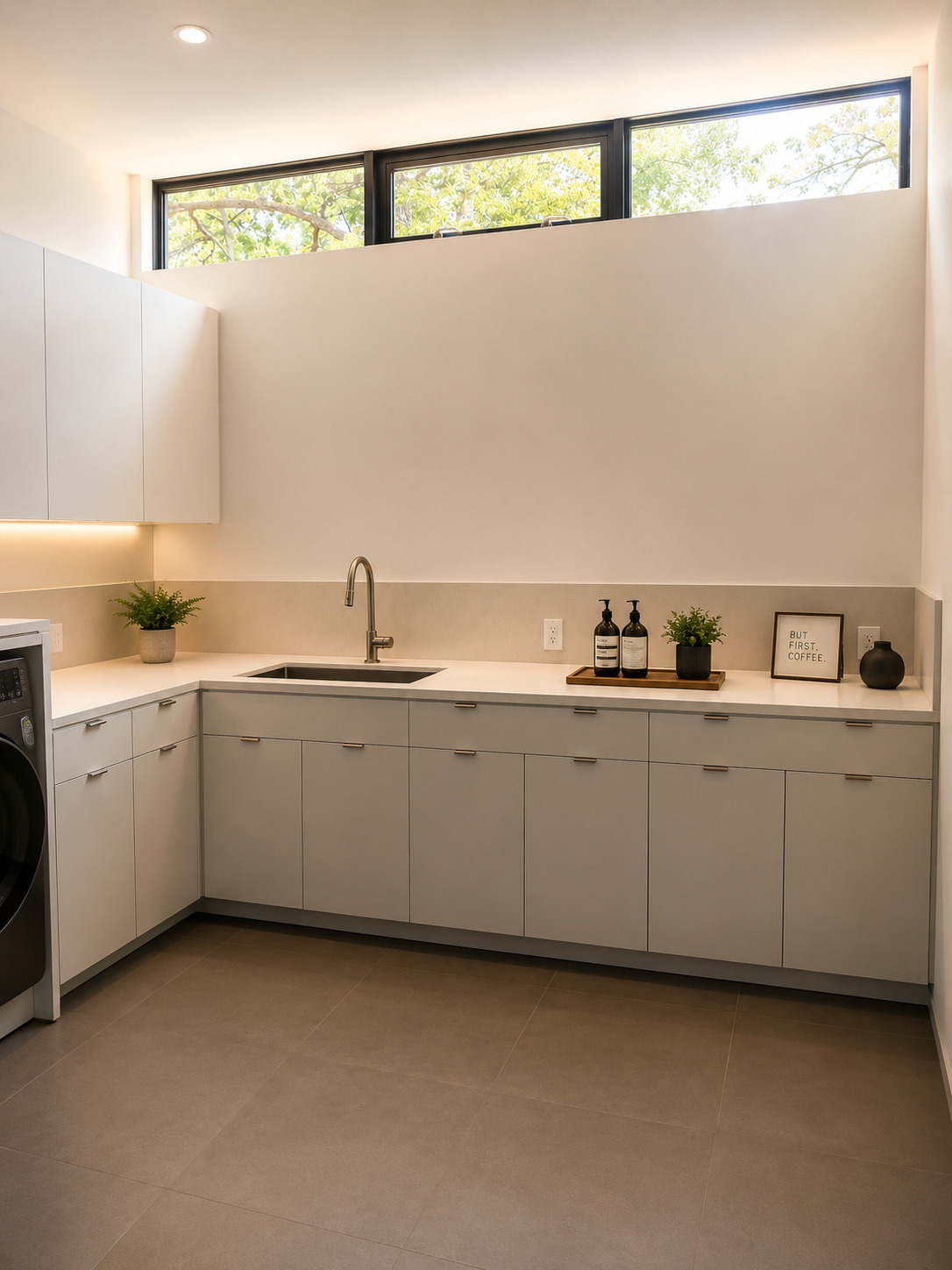 Light kitchen cabinet run with sink, wide counter, white upper cabinets, tall windows, and clean wall finish.