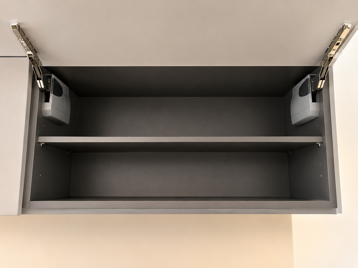 Open upper cabinet interior with dark finish, concealed lift hardware, and support arms.
