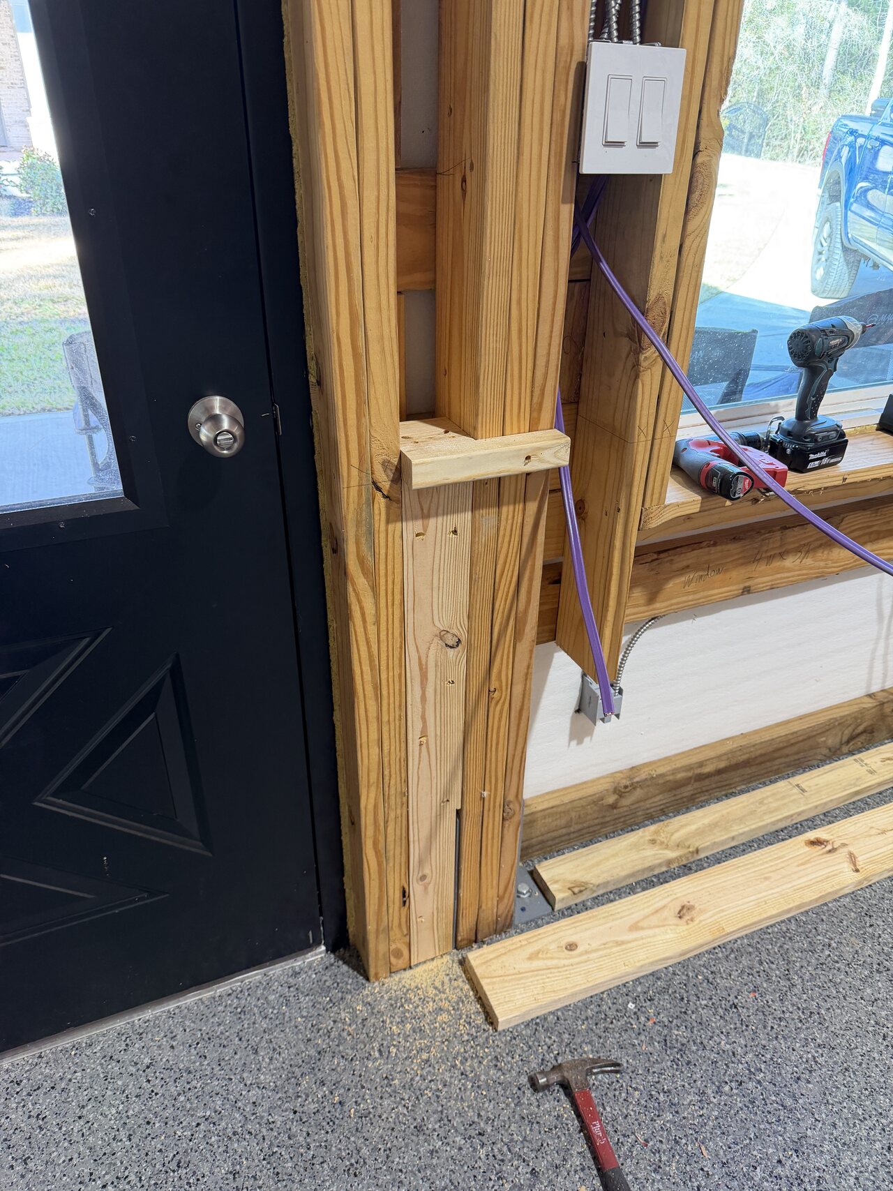 Door jamb and switch-side trim area during barn interior woodwork.