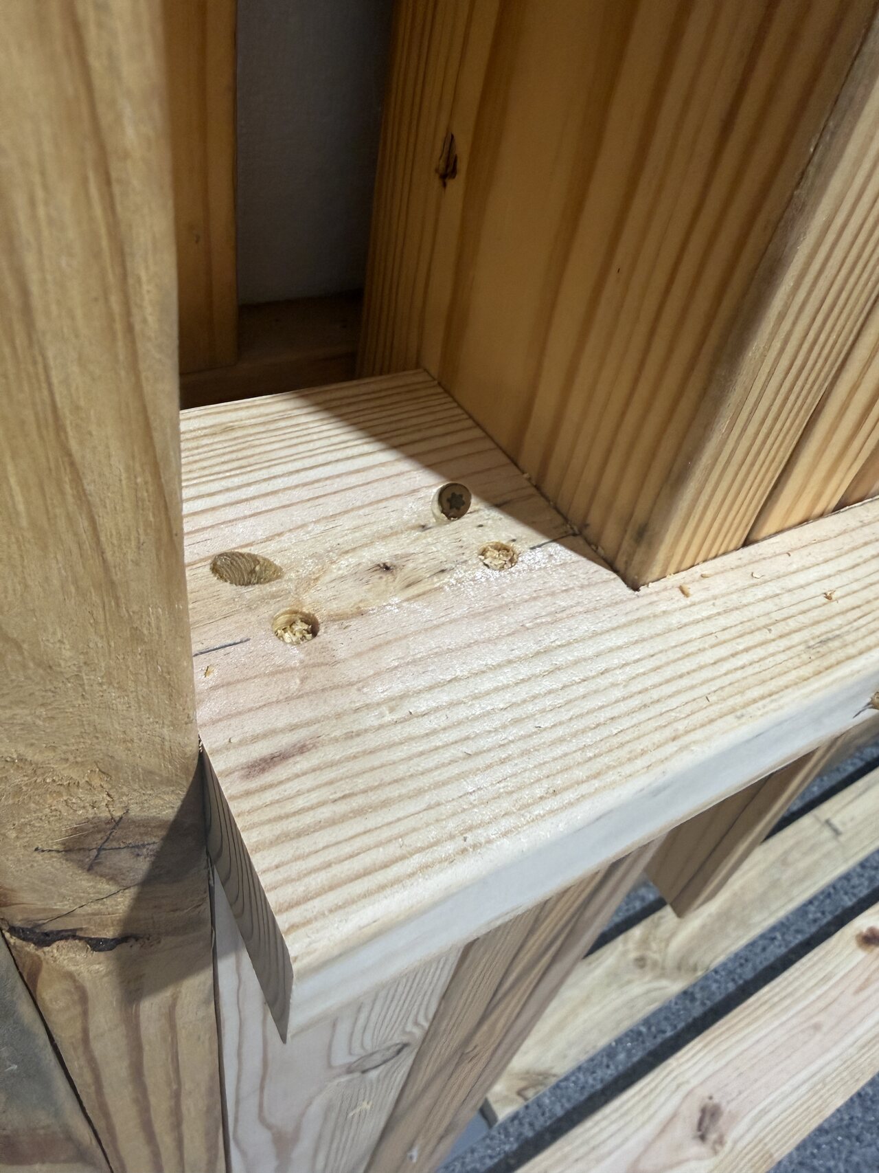 Close view of cut wood blocking and fitted pieces at a barn wall framing intersection.