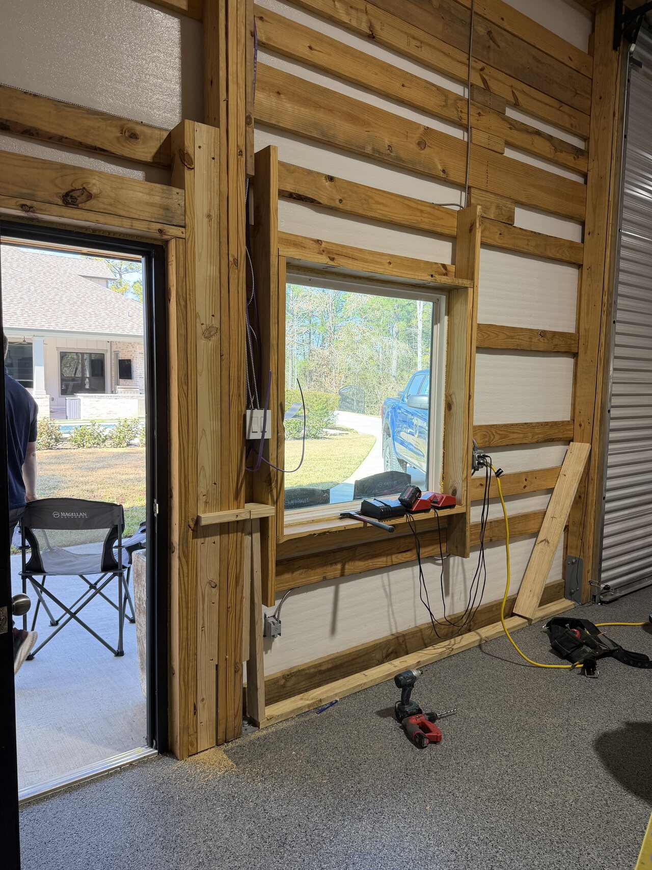 Door and window wall with lower wood rails and rough electrical visible before final trim completion.
