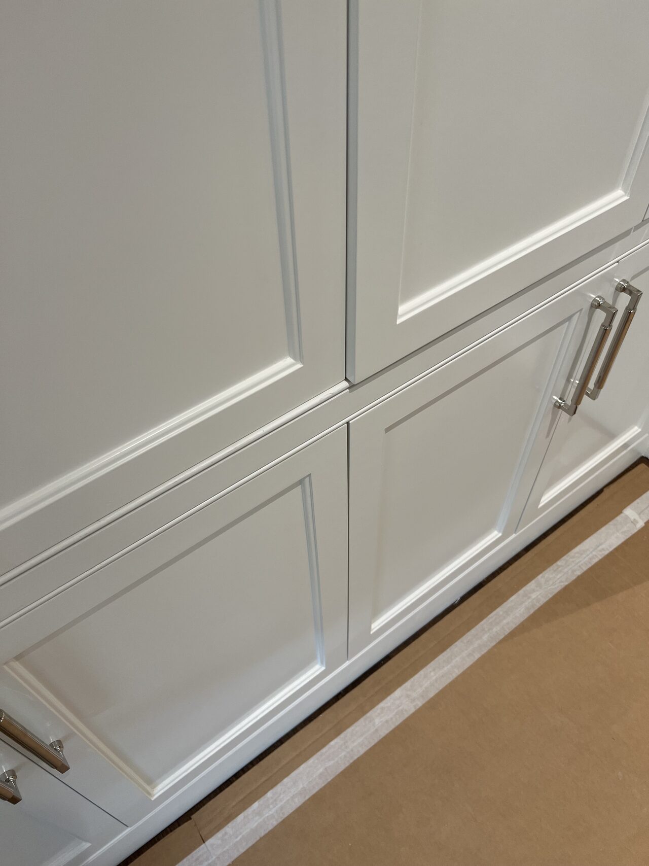 White vanity drawer and door faces reviewed for reveal alignment, hardware spacing, and cabinet front consistency for a Joel Hodge project.