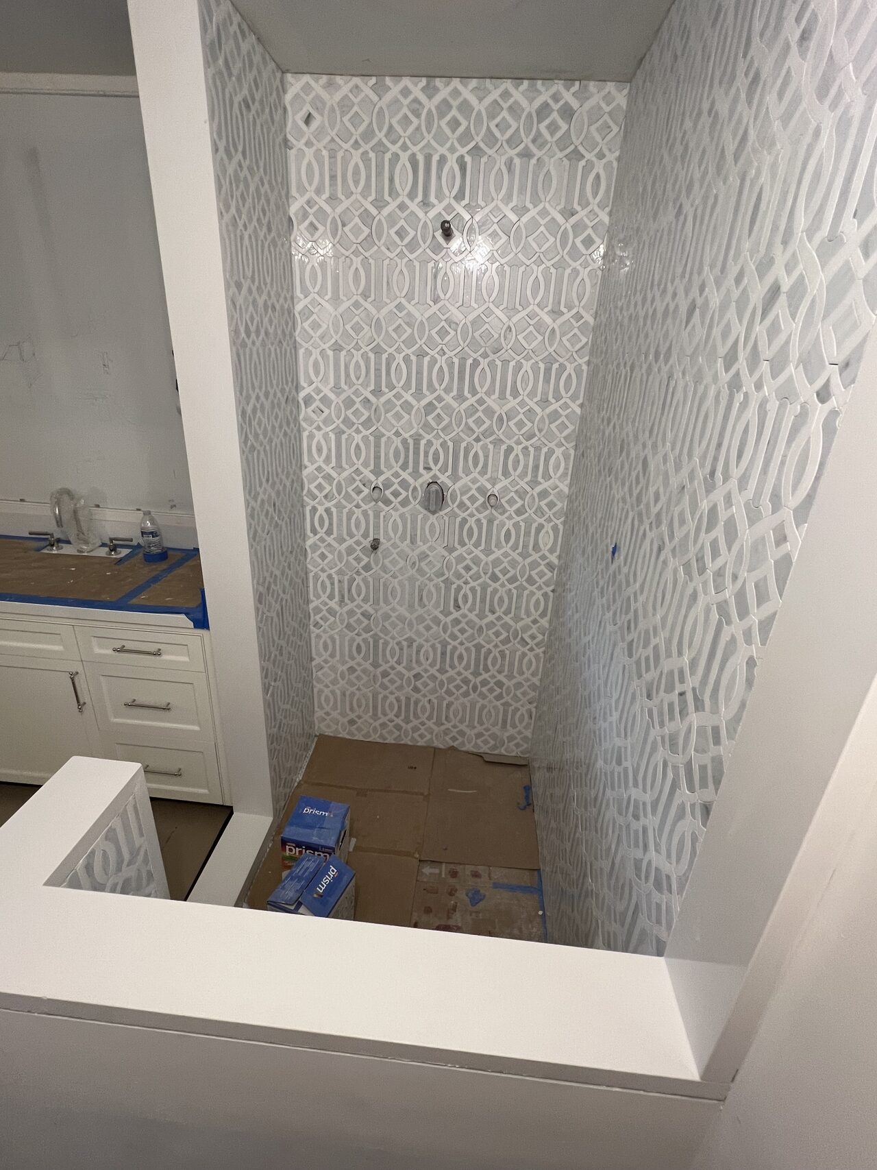 Tub and shower surround view showing the patterned tile niche, ledge, and waterproof finish areas after installation for a Joel Hodge project.