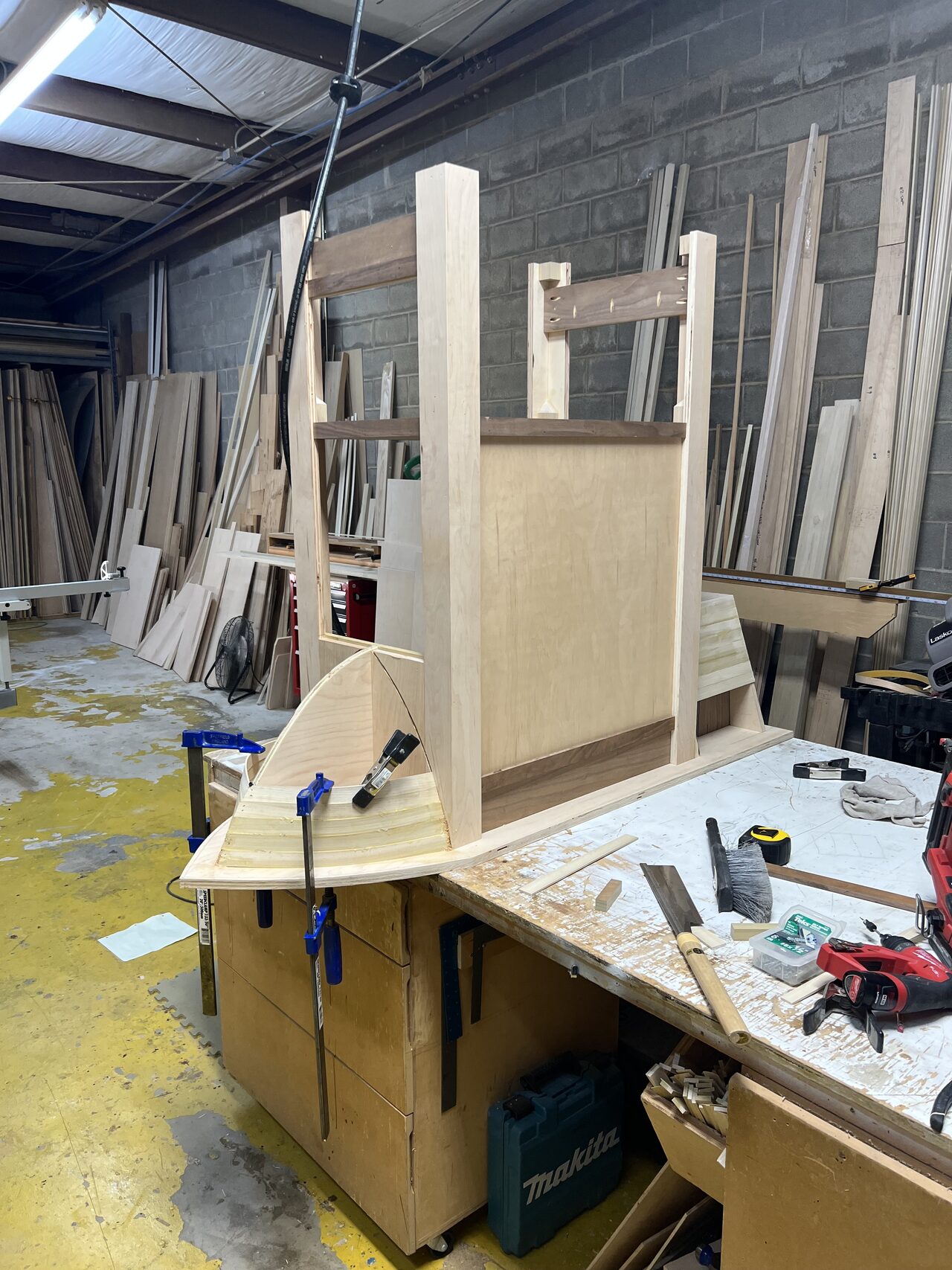 Shop bench setup for the curved millwork build with support blocks, clamps, and layout pieces in place for a Joel Hodge project.
