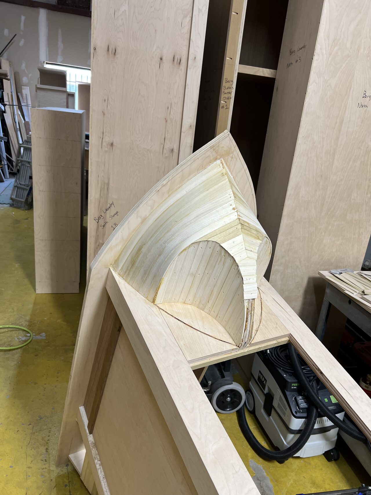 Stacked curved ribs and laminated sections reviewed against the cabinet side for consistent radius spacing for a Joel Hodge project.
