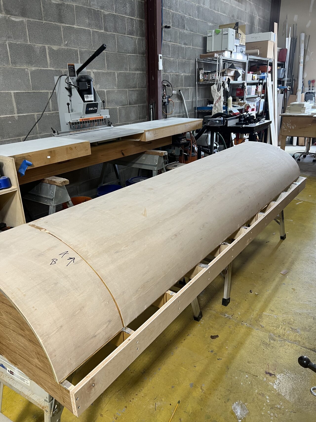 Long curved laminated section on the bench before final trimming, edge cleanup, and finish preparation for a Joel Hodge project.