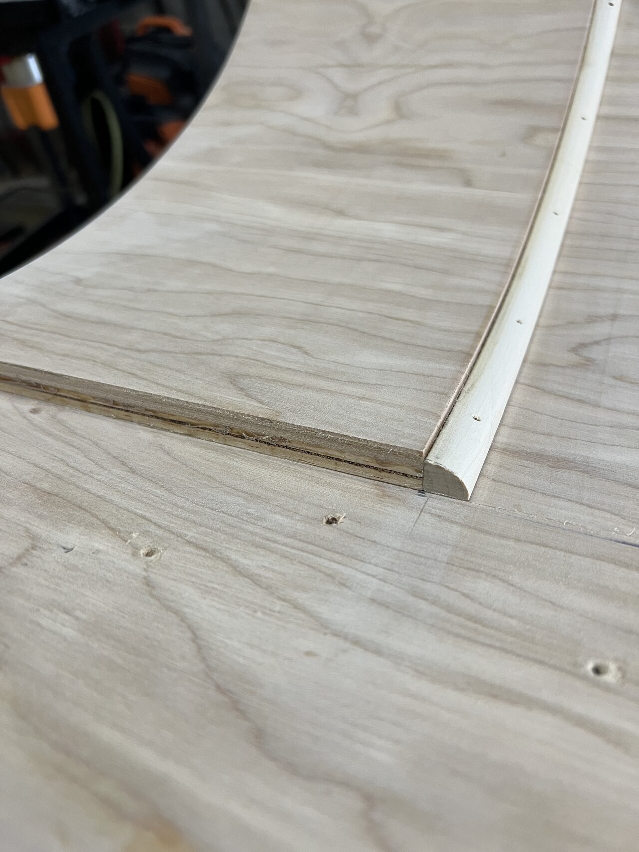 Close-up of grain direction and edge detail on a radius piece after the curved profile was shaped for a Joel Hodge project.