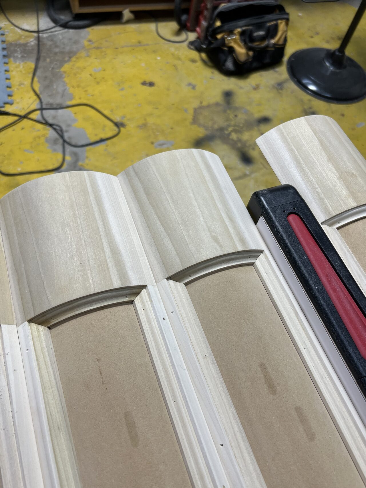 Completed curved trim/profile pieces stacked and ready for installation or finishing for a Joel Hodge project.