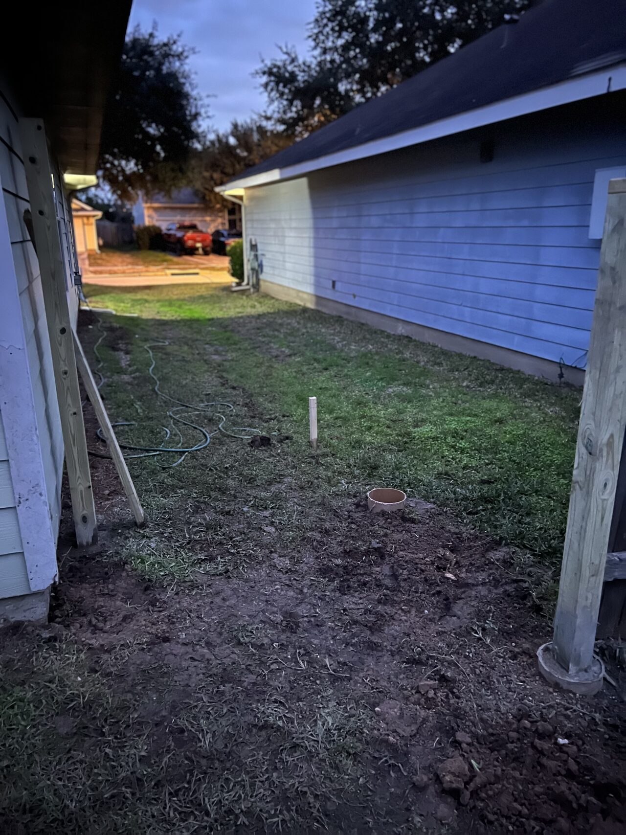 Side-yard fence line and access path reviewed before the custom gate and exterior panel work began for a Joel Hodge project.