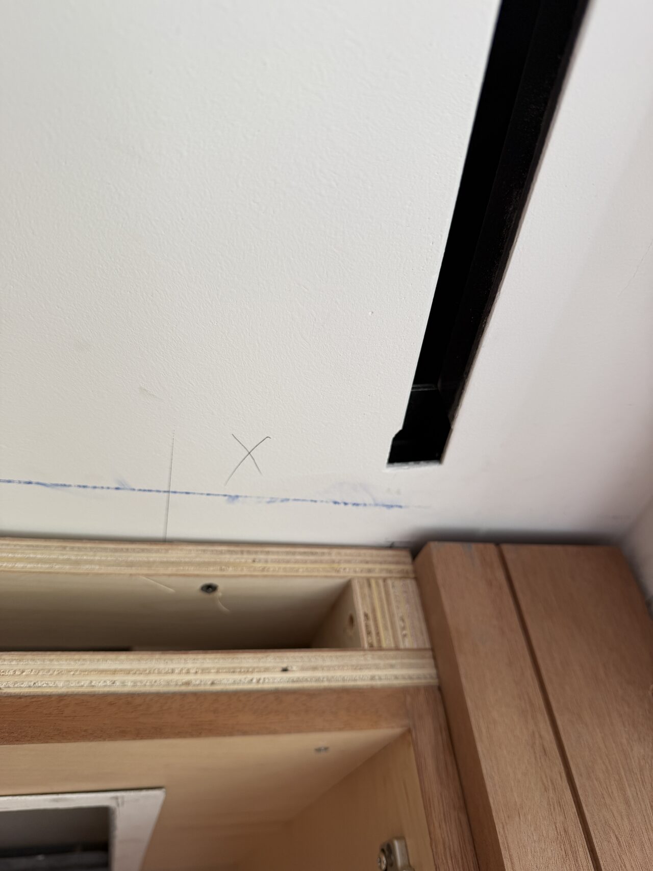 Ceiling reveal and upper trim line checked above the wood built-in for lighting and finish clearance for a Joel Hodge project.