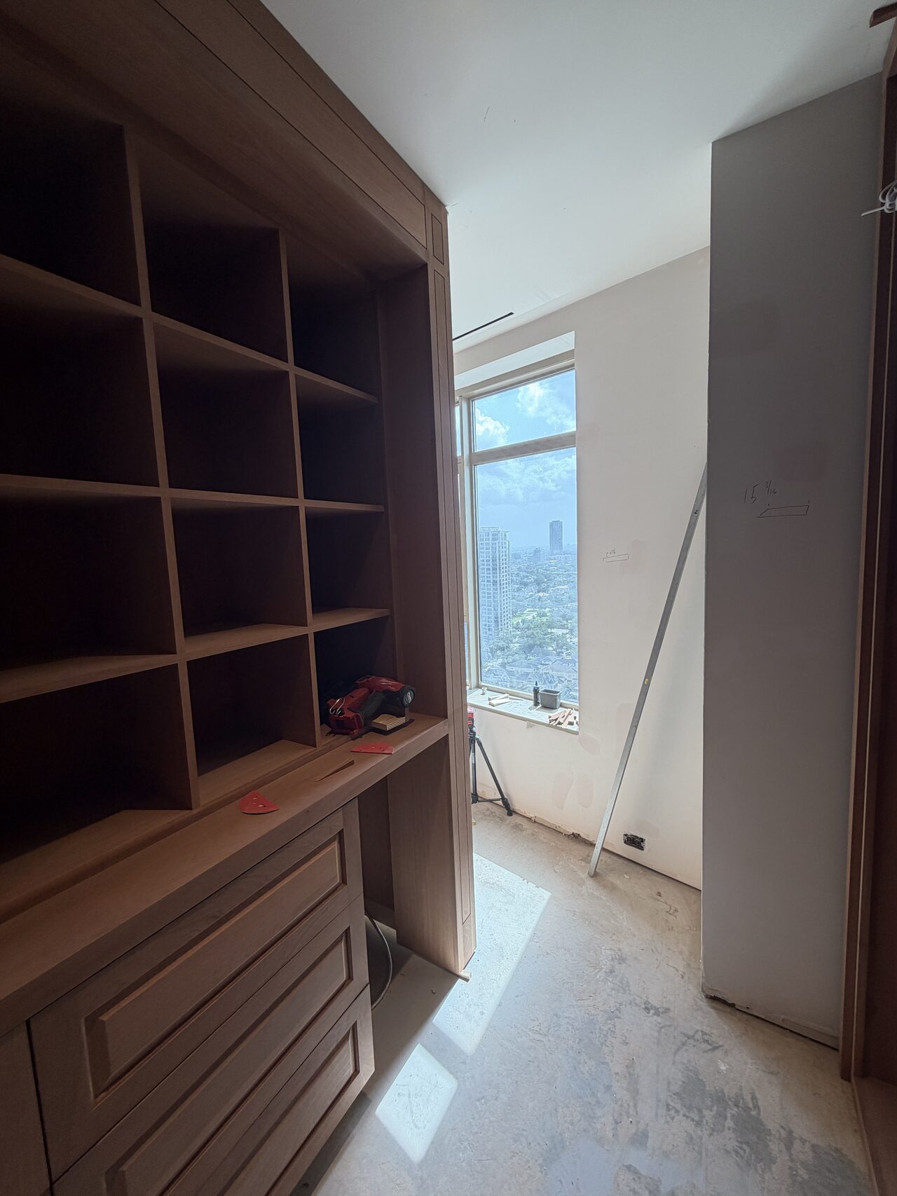 Dark wood closet shelving and drawer bank reviewed for storage layout and window-side fit for a Joel Hodge project.