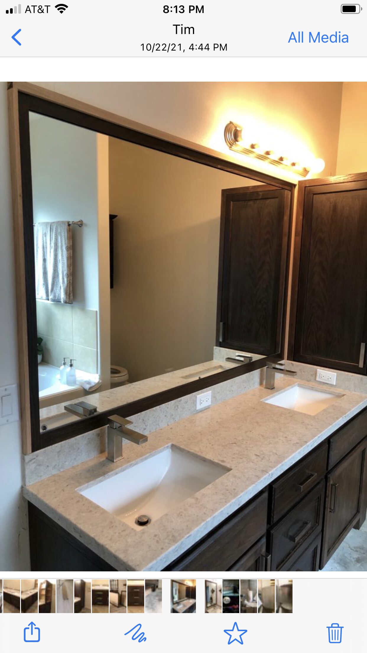 Phone reference image showing the dark vanity and mirror arrangement used for finish-detail review for a Joel Hodge project.
