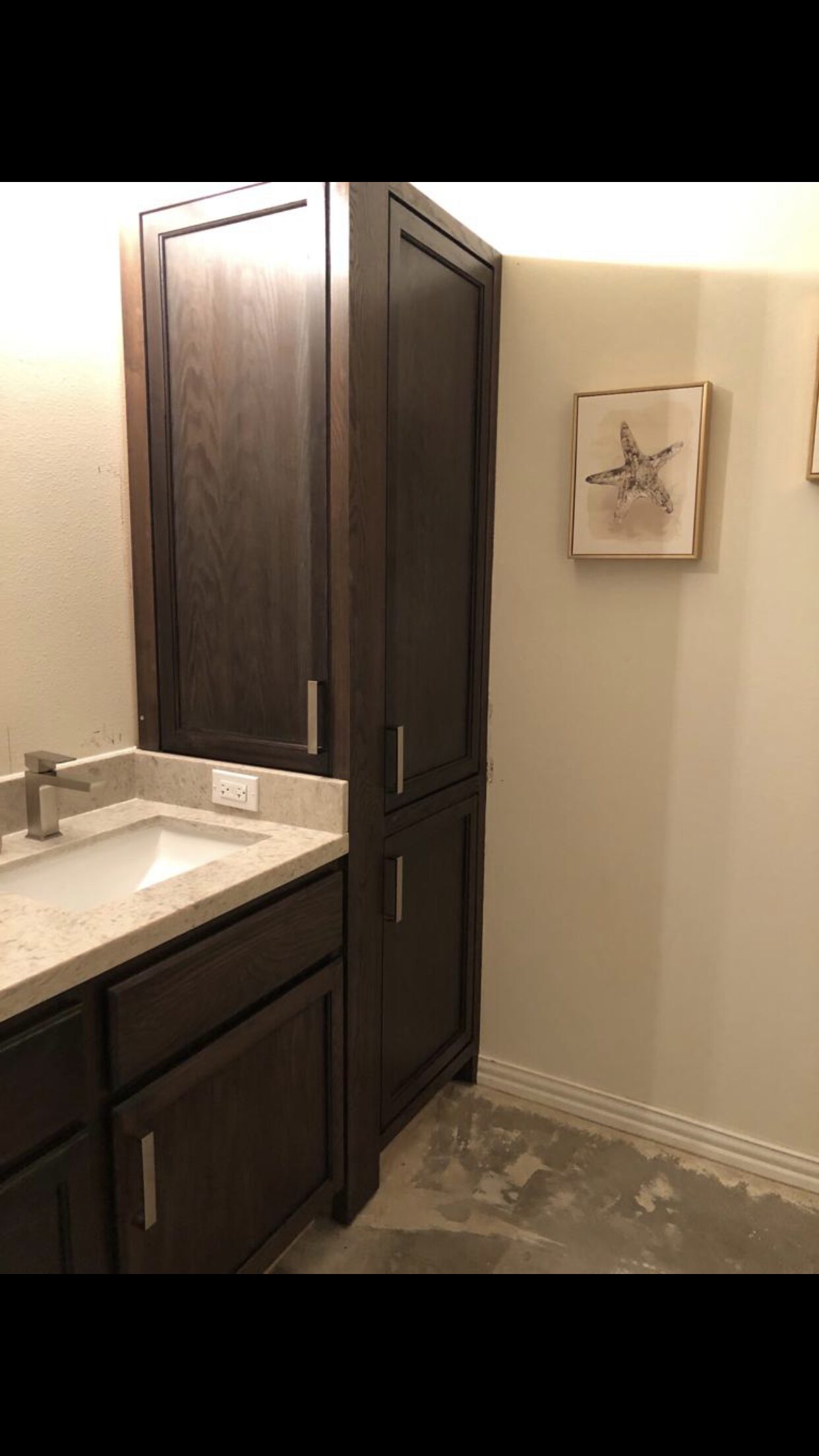 Dark vanity side panel and wall trim corner reviewed for reveal, paint line, and cabinet fit for a Joel Hodge project.