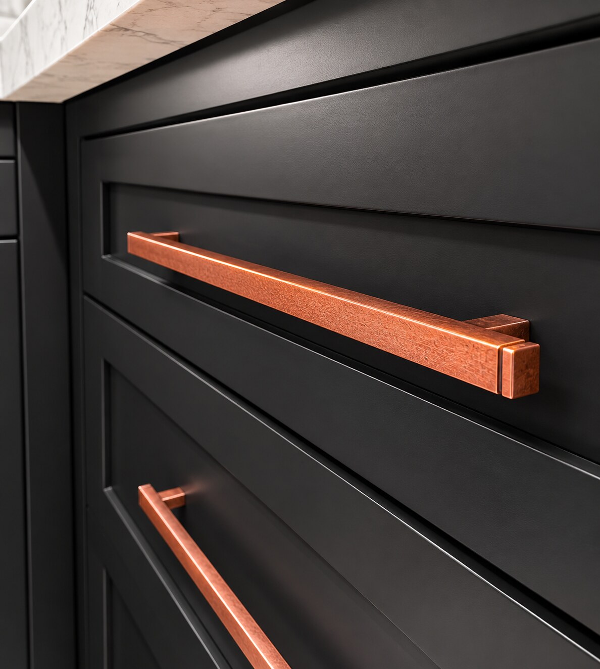 Close view of dark inset cabinet drawer fronts with copper-toned pulls and even spacing between the fronts.