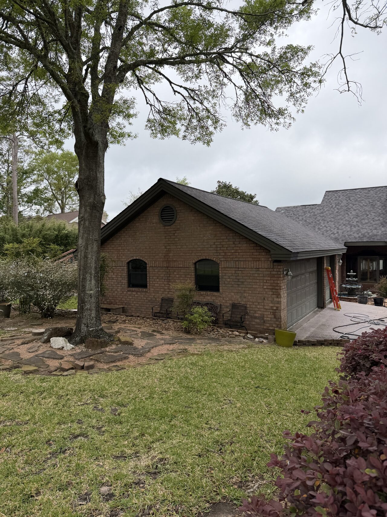 Front elevation under the trees reviewed for gable trim, roofline, and upper window context for a Joel Hodge project.