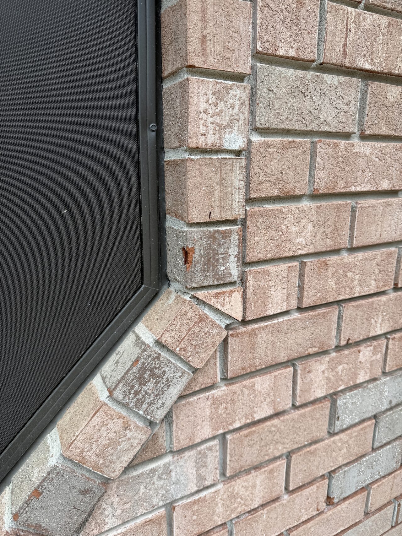 Close-up of brick, window sill, and trim joint used to review water exposure and finish transitions for a Joel Hodge project.