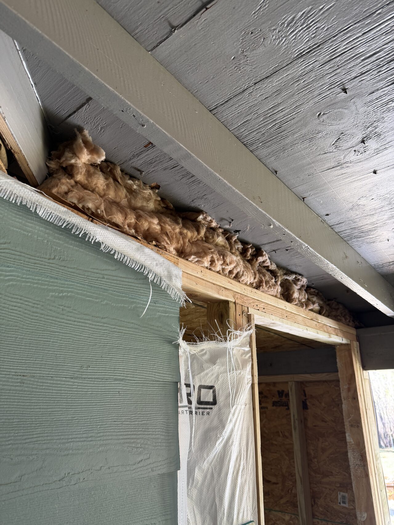 Opened soffit and eave area documented to understand existing material conditions above the siding for a Joel Hodge project.