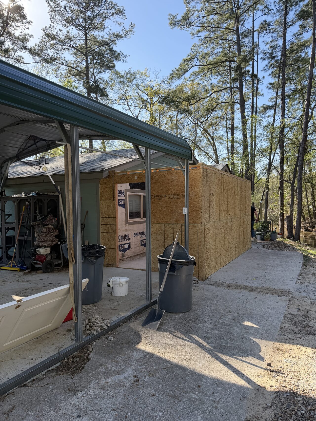 Exterior wall framing and sheathing work zone reviewed under the covered side area for a Joel Hodge project.