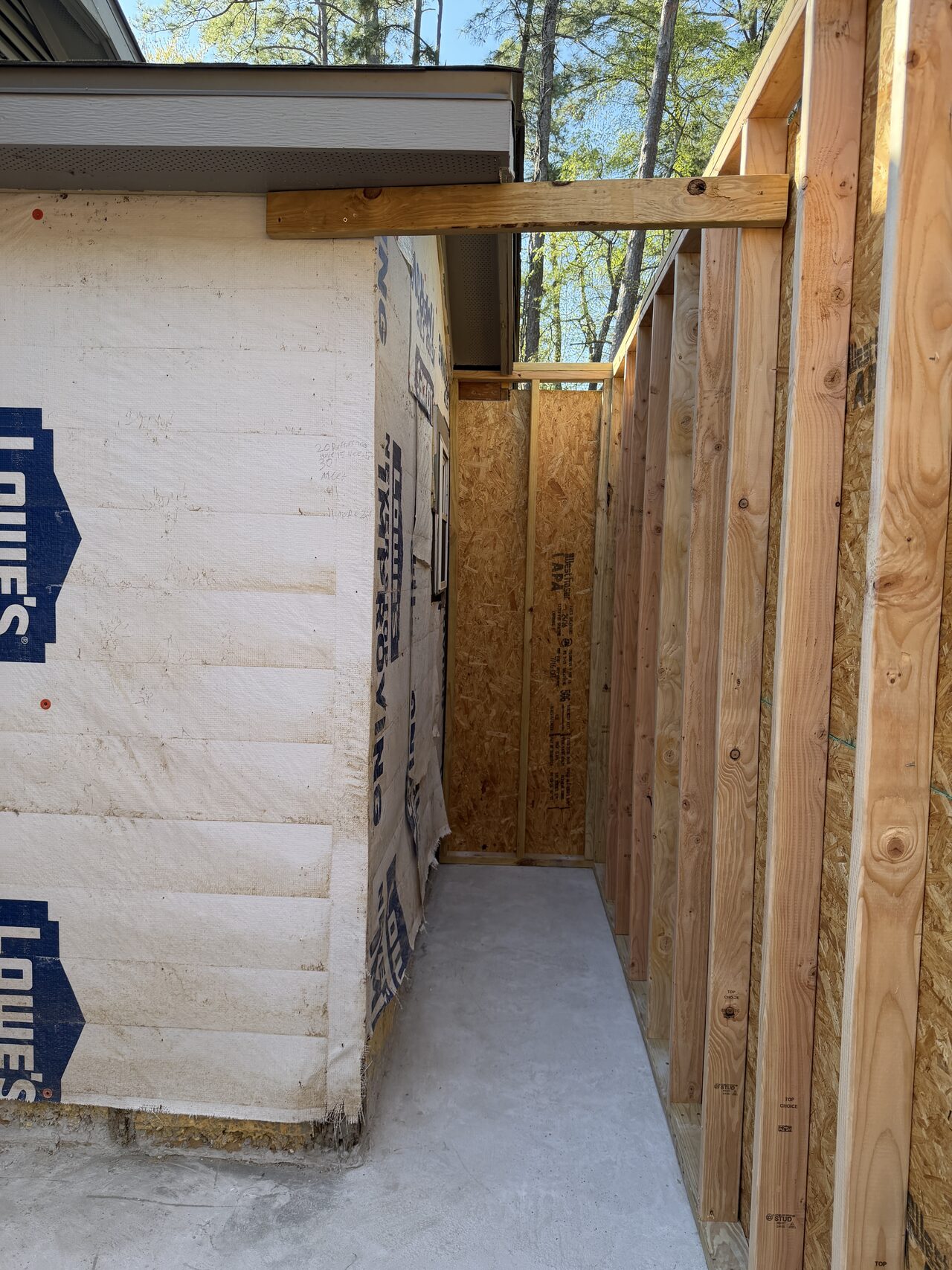 Corner wall opening and sheathing layout checked before door or window finish work continued for a Joel Hodge project.