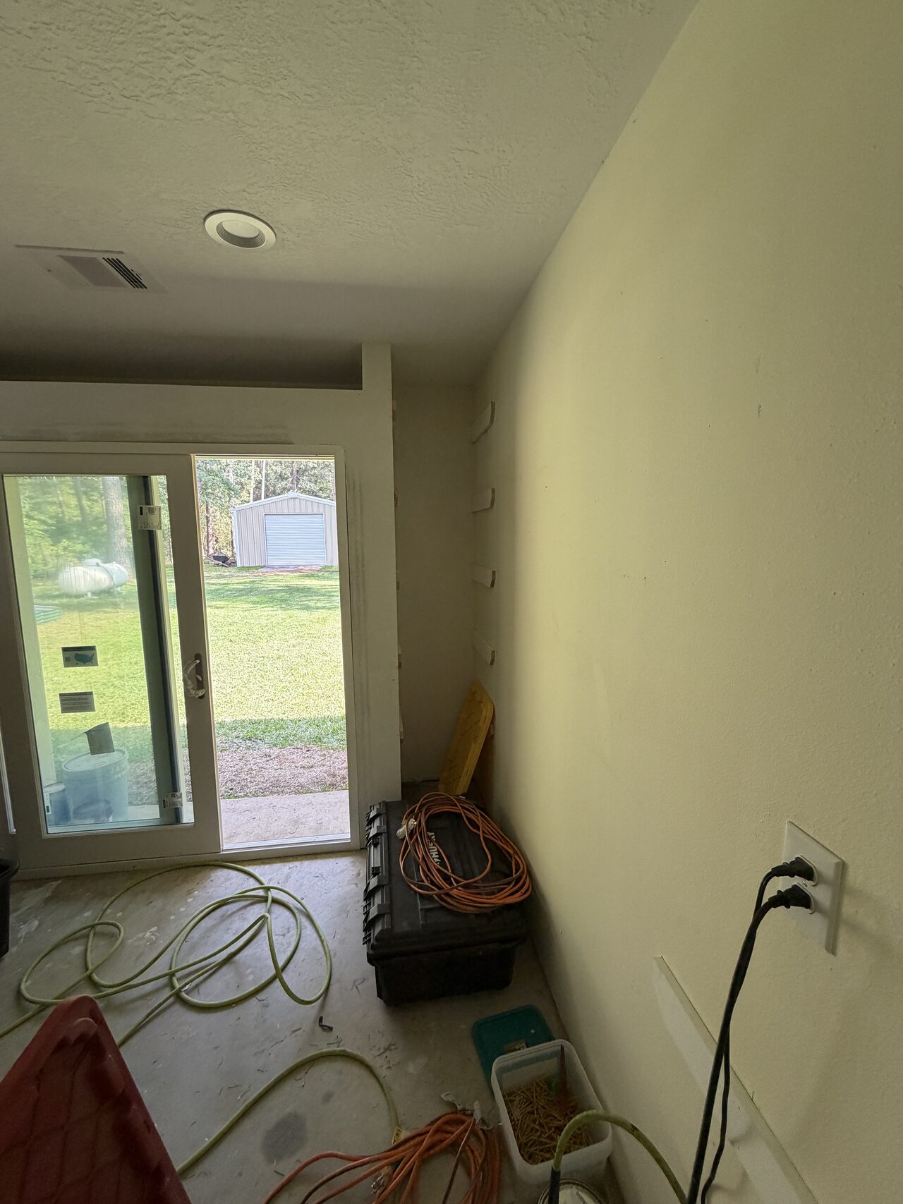 Interior room view showing tools, cords, and opening layout before finish work was completed for a Joel Hodge project.