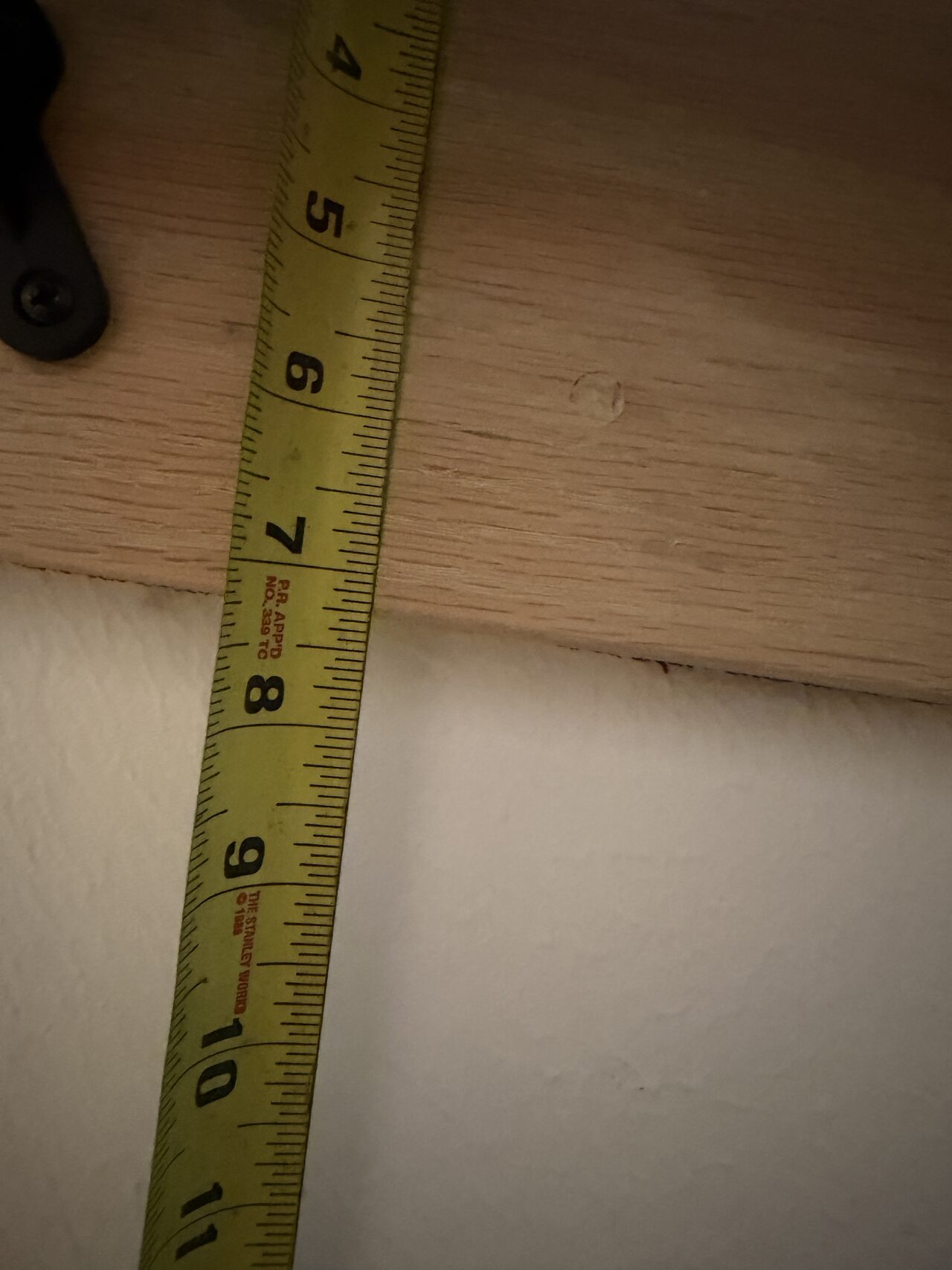 Tape measurement at the stair edge used to confirm tread or trim dimensions before refresh work for a Joel Hodge project.