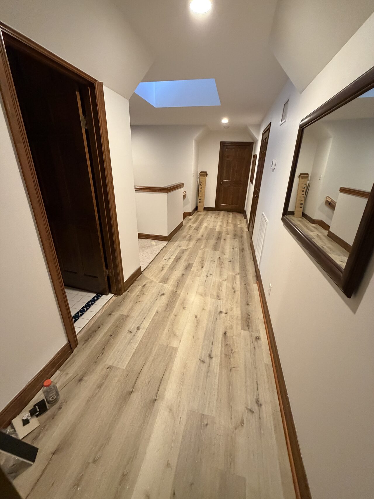 Hall flooring and baseboard run reviewed for straight transitions and finish consistency for a Joel Hodge project.