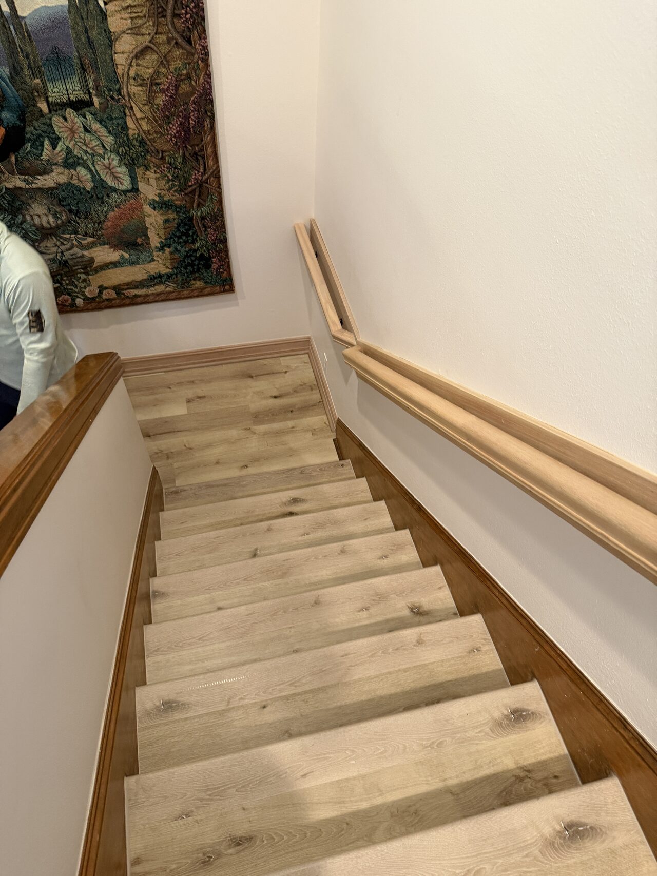Upper stair run showing tread surfaces and handrail alignment after finish work for a Joel Hodge project.