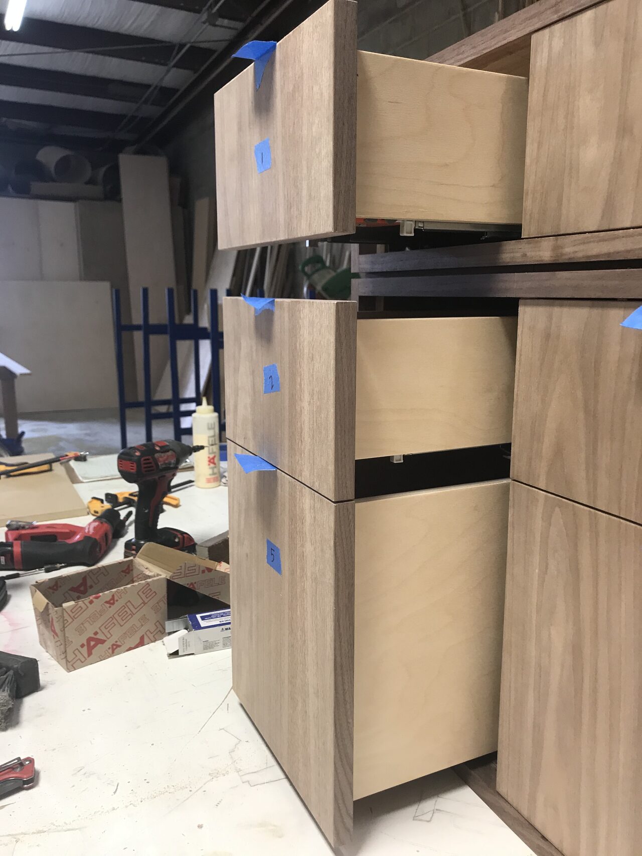 Tall cabinet section with drawer stack and side panel checked for vertical alignment in the shop for a Joel Hodge project.