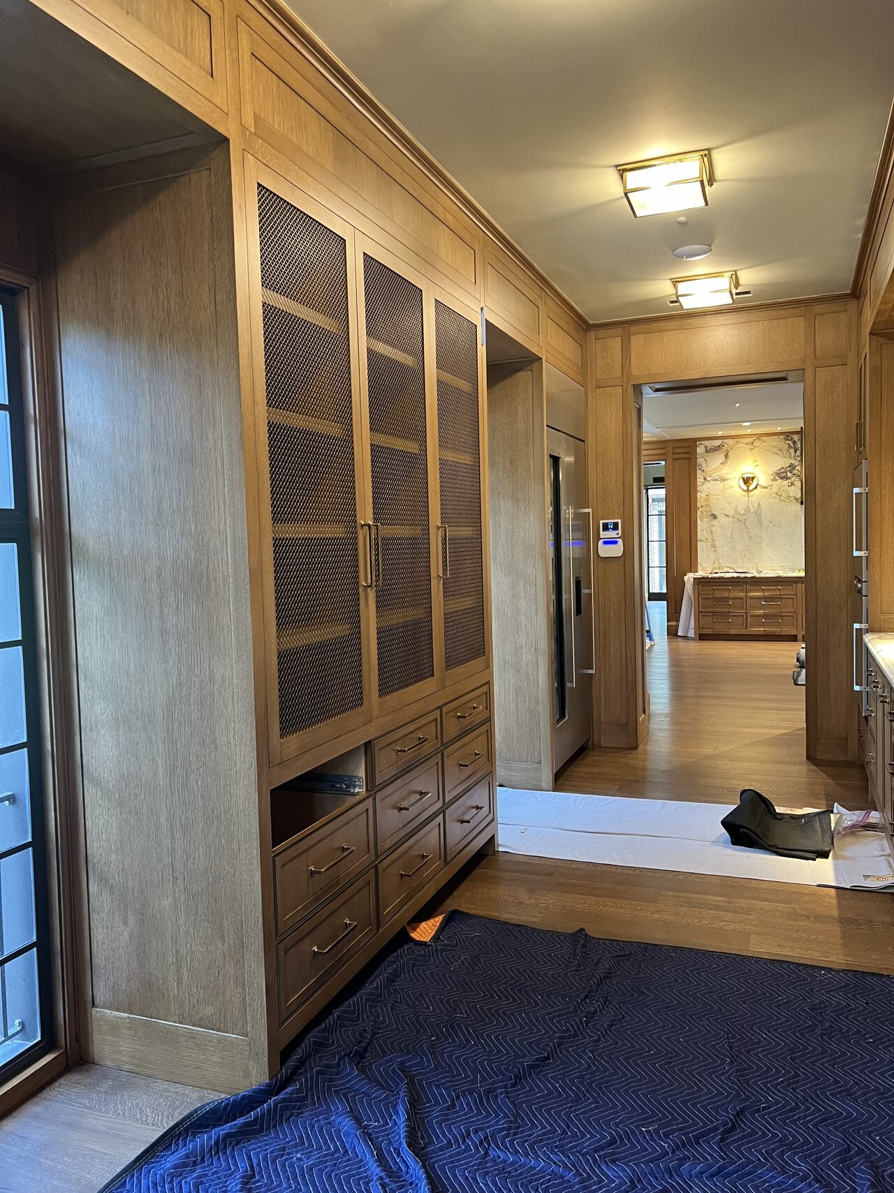 Wood panel and glass-door cabinet run reviewed for vertical alignment and room-side sight lines for a Joel Hodge project.