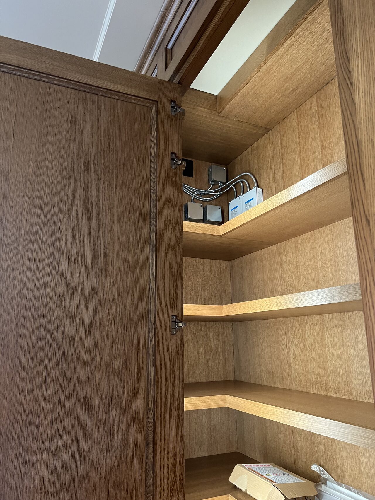 Interior shelving and side panel detail checked for clean joinery inside the tall cabinet run for a Joel Hodge project.