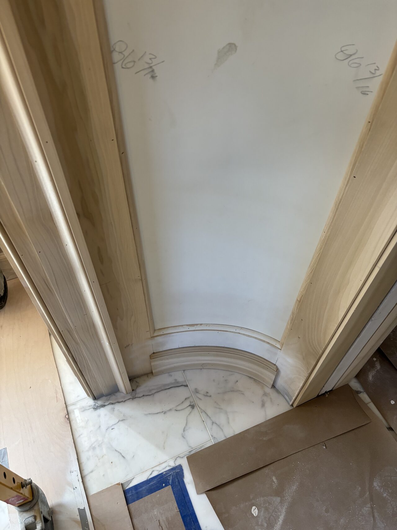 Curved floor or base transition near the paneled opening reviewed for scribe and trim fit for a Joel Hodge project.