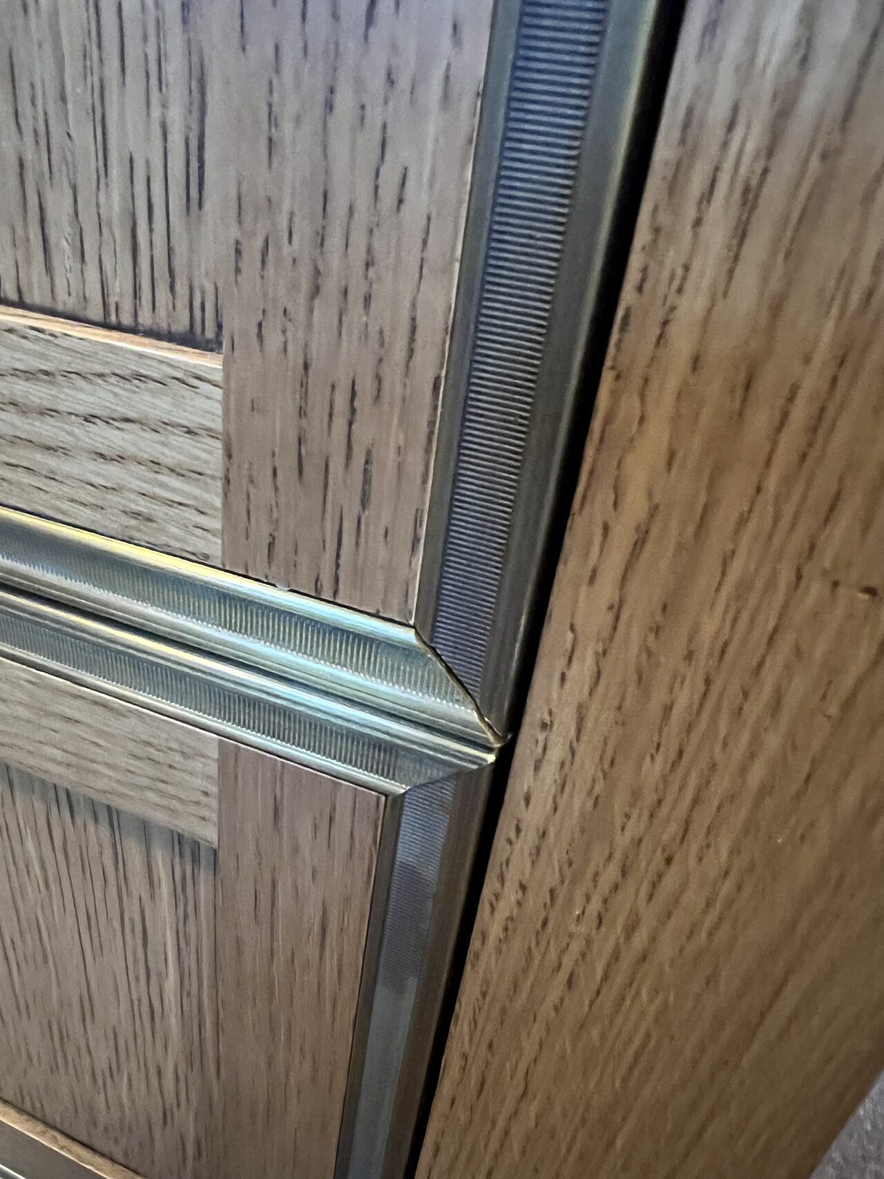 Detailed view of wood stile, inset panel, and finish profile where the cabinet face meets trim for a Joel Hodge project.