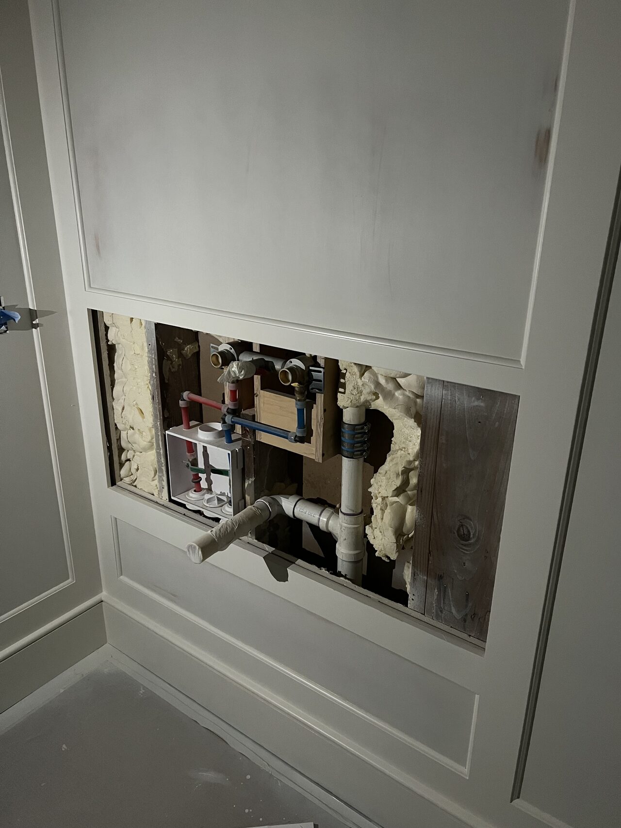 Wall-open plumbing area documented before the small vanity cabinet was closed in and finished for a Joel Hodge project.