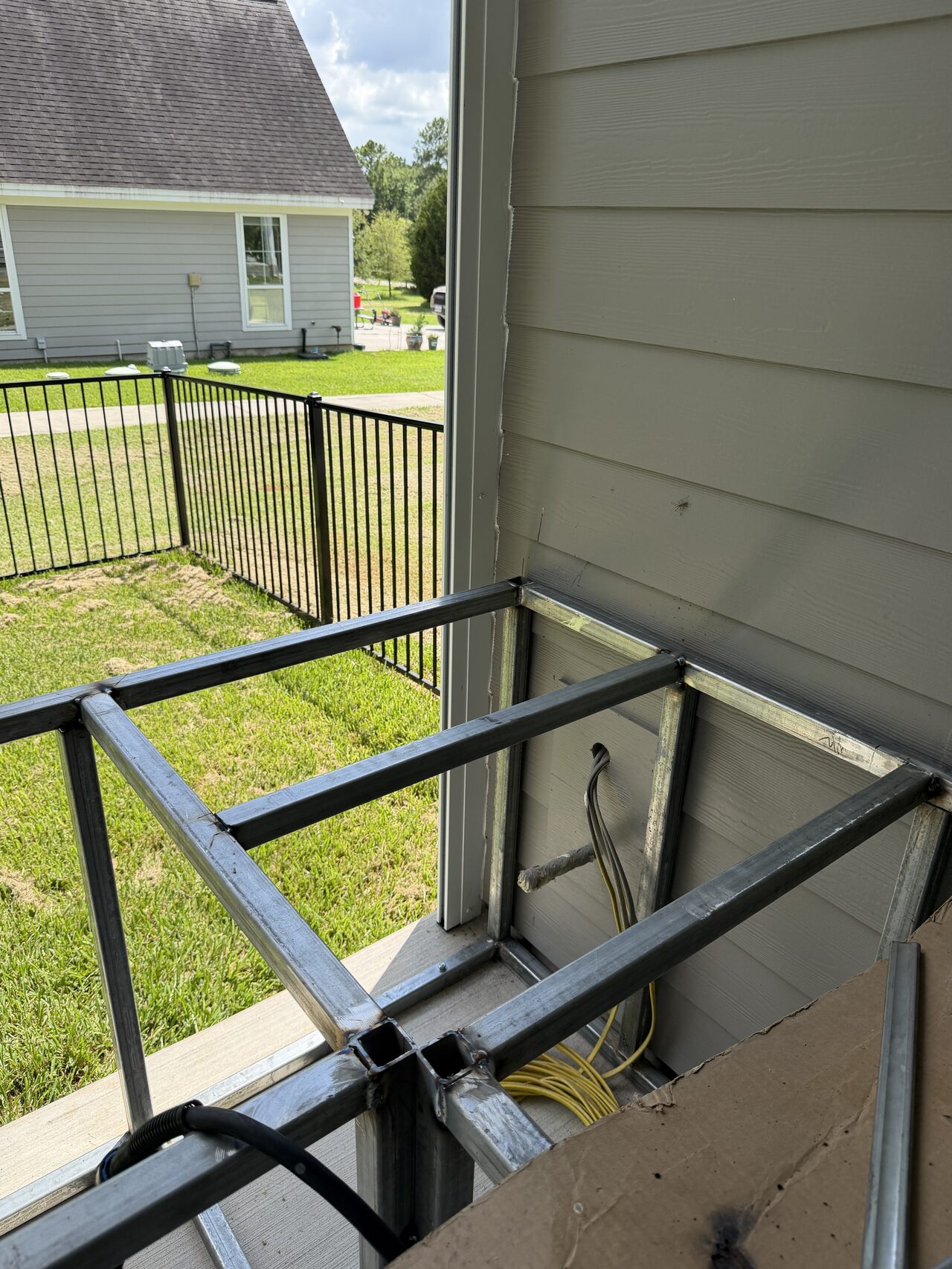 Side railing frame and post locations documented near the house wall before final panel work for a Joel Hodge project.