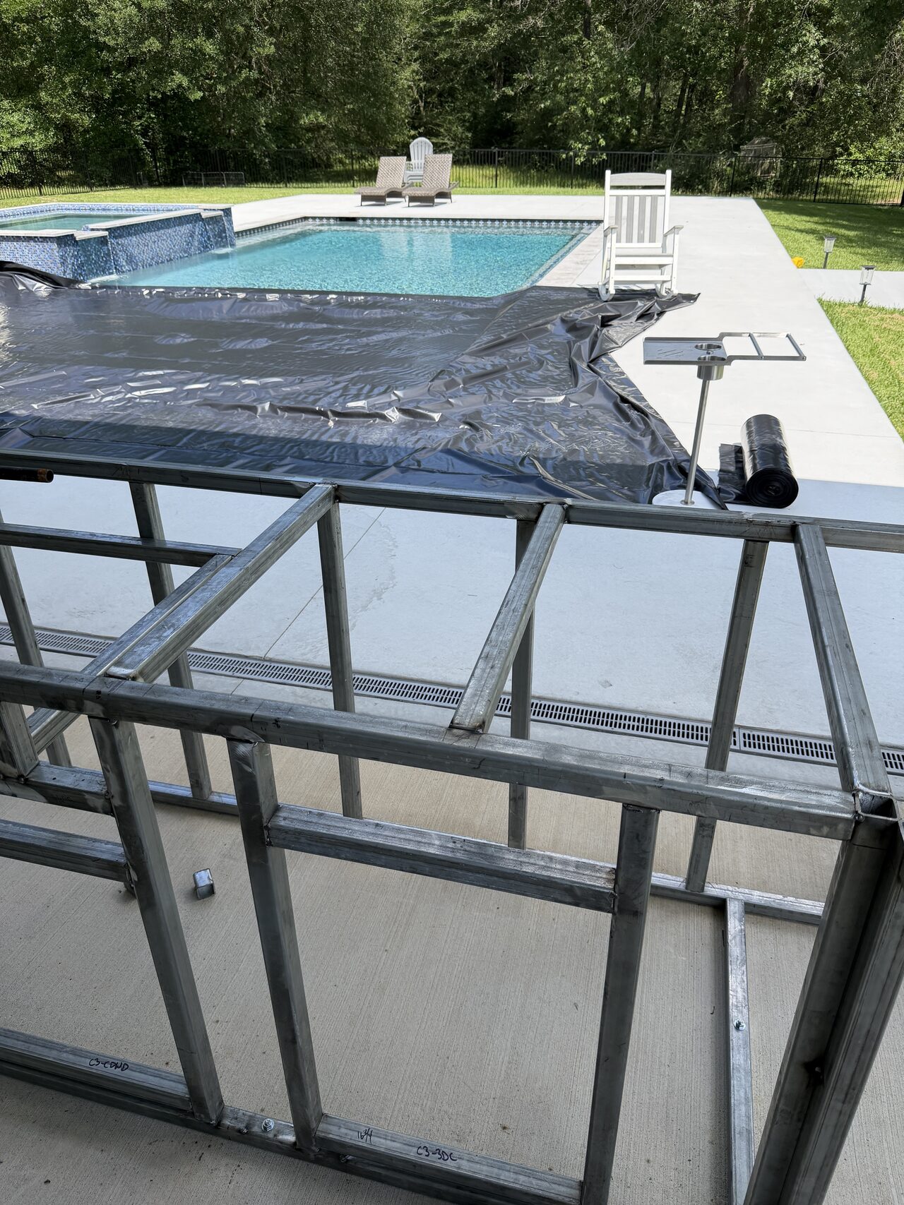 Pool-facing railing frame checked from above with panel layout and cap alignment visible for a Joel Hodge project.
