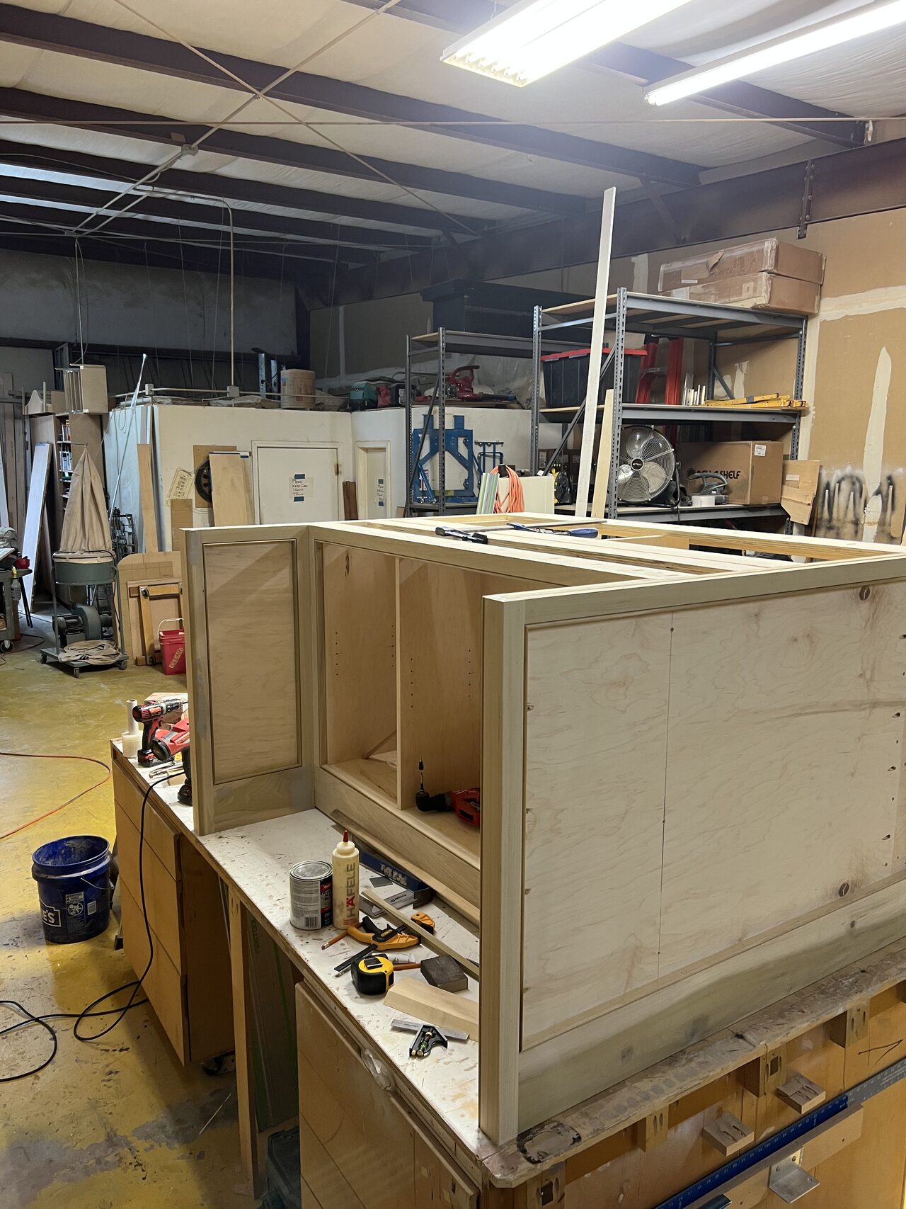 Shop-built cabinet boxes staged together while face frames and storage sections were being prepared for a Joel Hodge project.