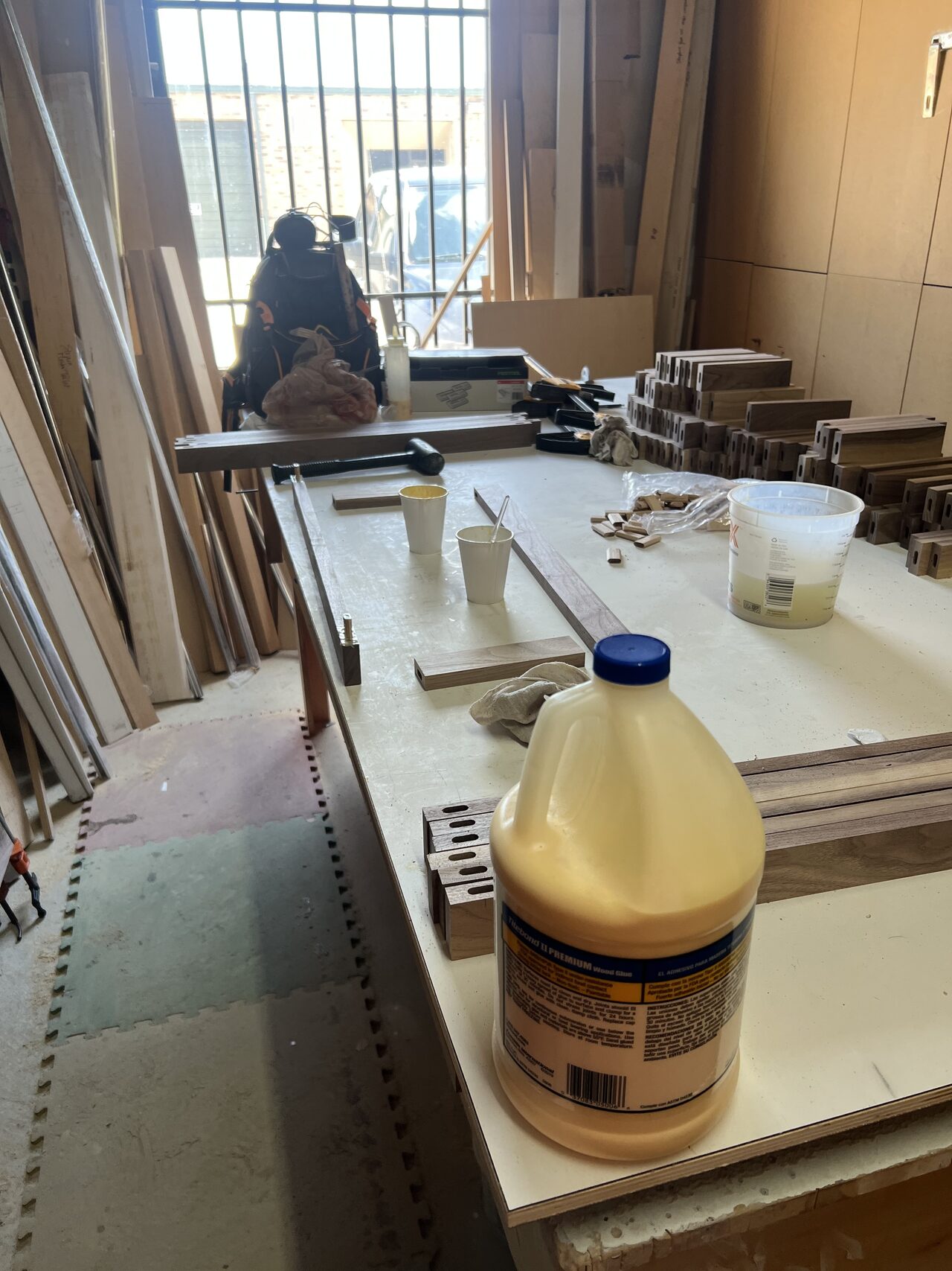 Large panel and cabinet parts laid out in the shop before assembly and finish work for a Joel Hodge project.