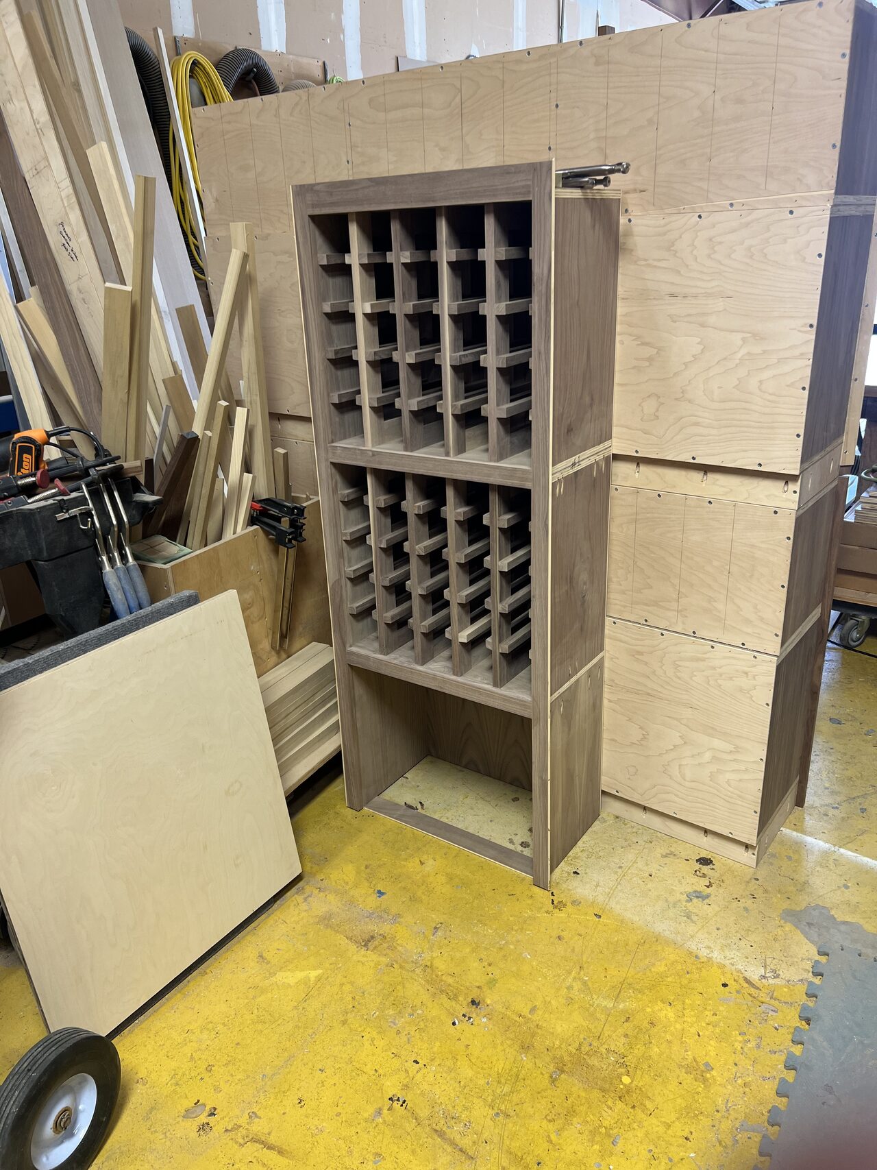 Wine storage cabinet standing in the shop with grid insert and lower cabinet bay installed for a Joel Hodge project.