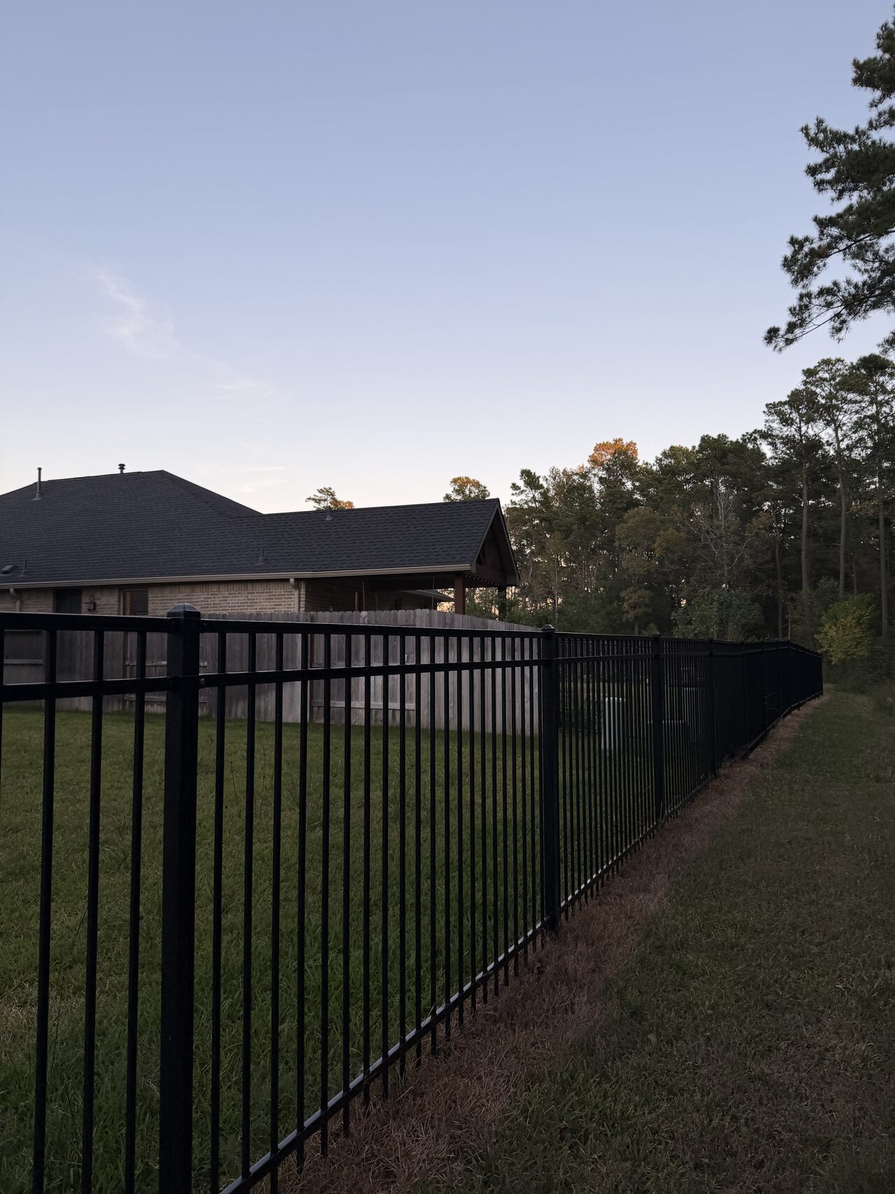Fence line and backyard edge reviewed for drainage direction and walkway placement for a Joel Hodge project.