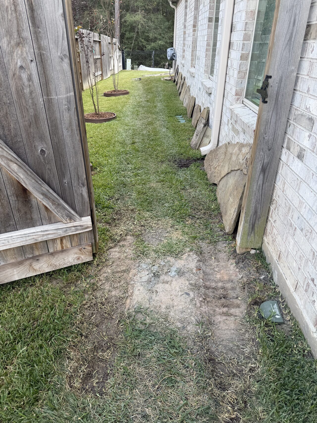 Narrow side-yard route reviewed before grading and walkway work between fence lines for a Joel Hodge project.