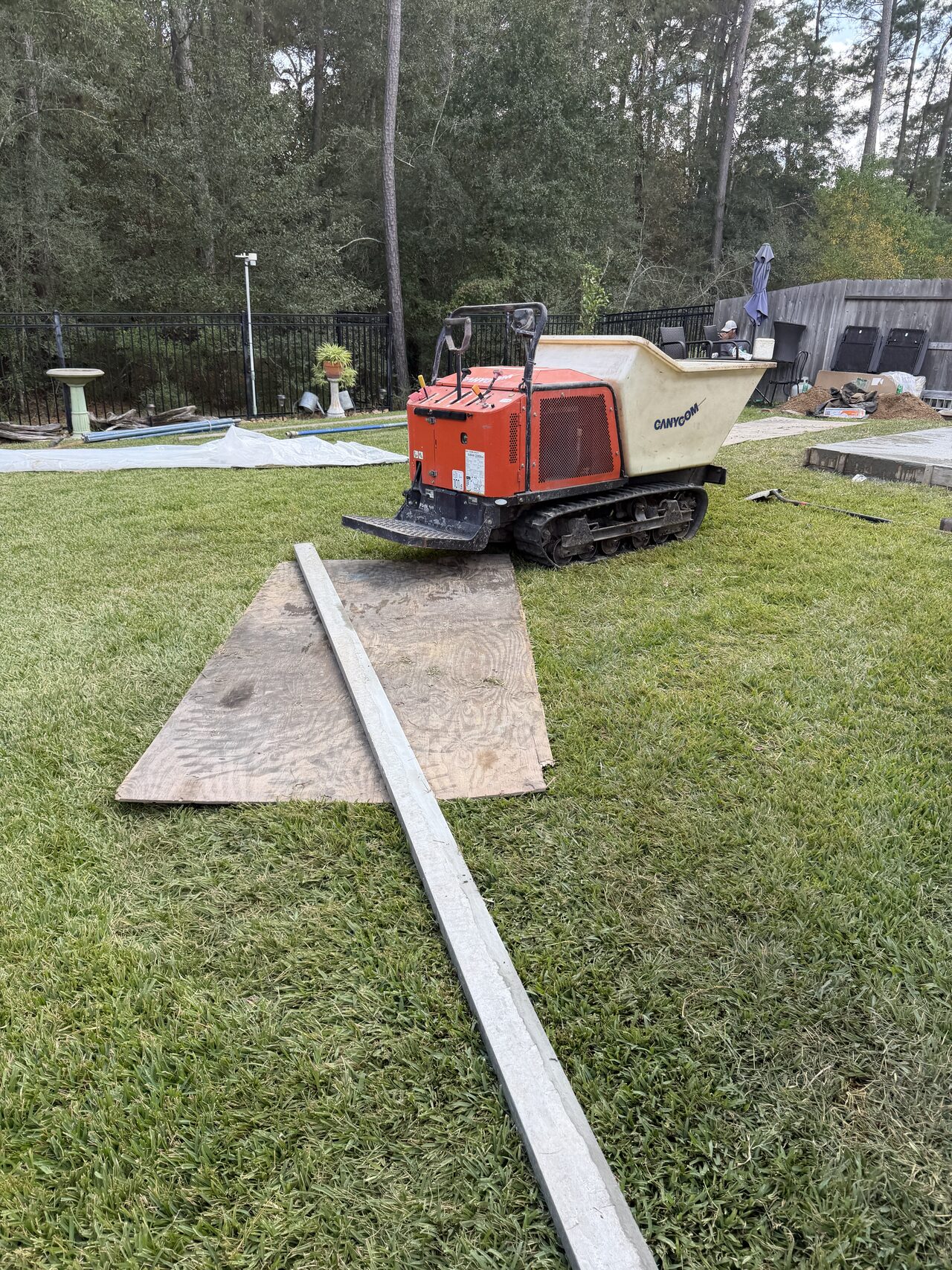 Boards and equipment staged in the yard for concrete forming and site preparation for a Joel Hodge project.