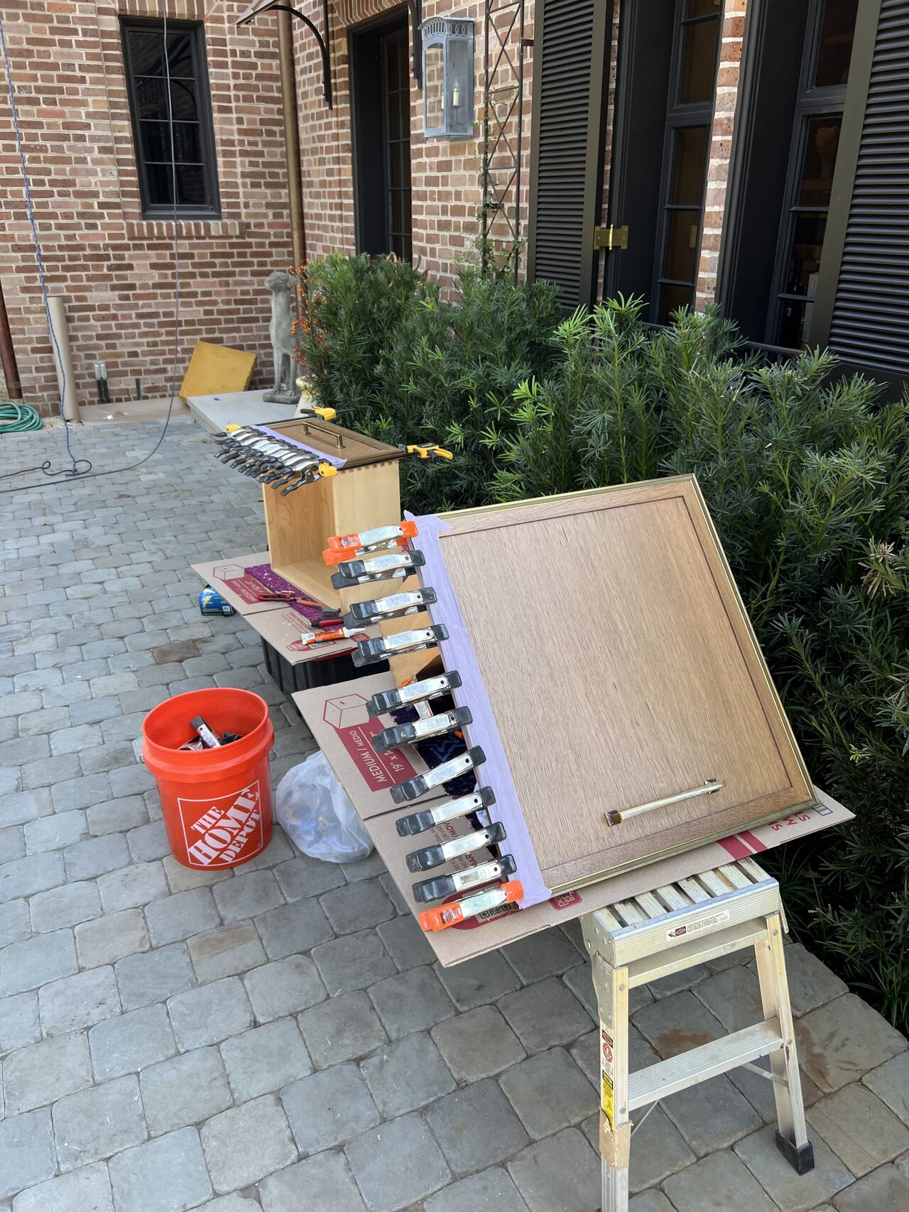 Paint and finish samples staged outside to compare color options for cabinet or trim work for a Joel Hodge project.