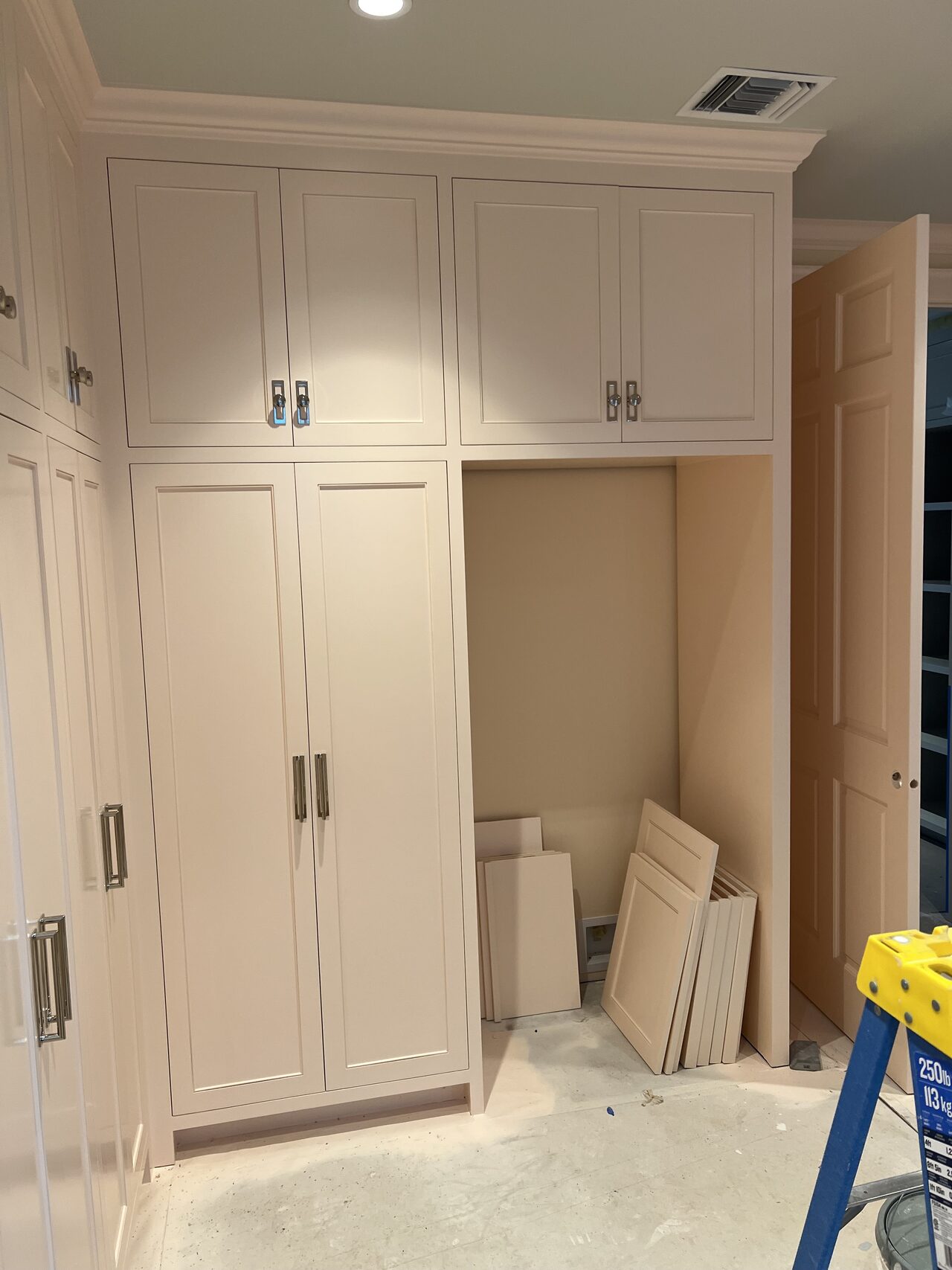 Tall wardrobe-style cabinet section checked for door alignment and upper storage fit for a Joel Hodge project.