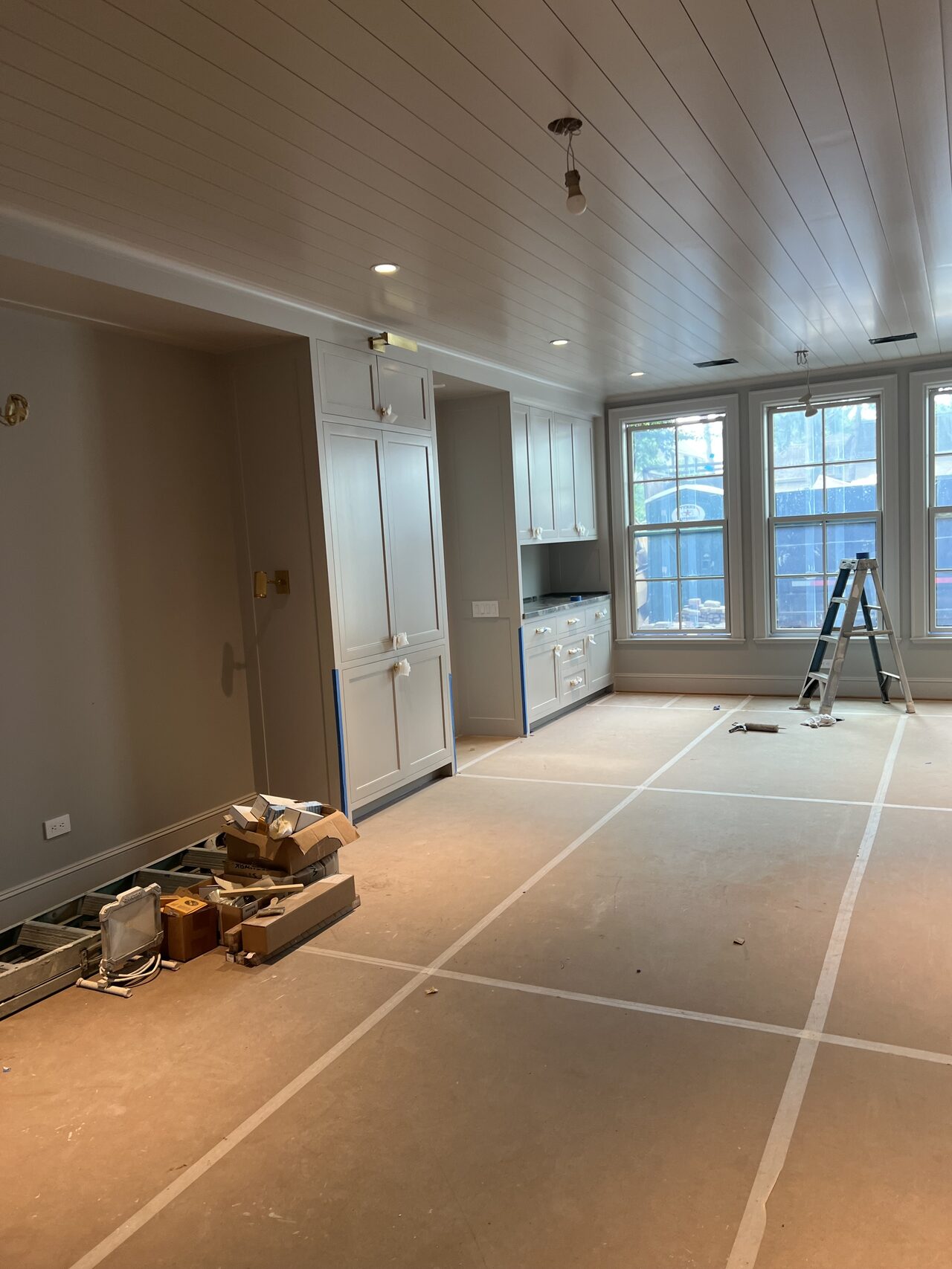 Room-wide view showing protected floor paths while built-ins and trim were being completed for a Joel Hodge project.