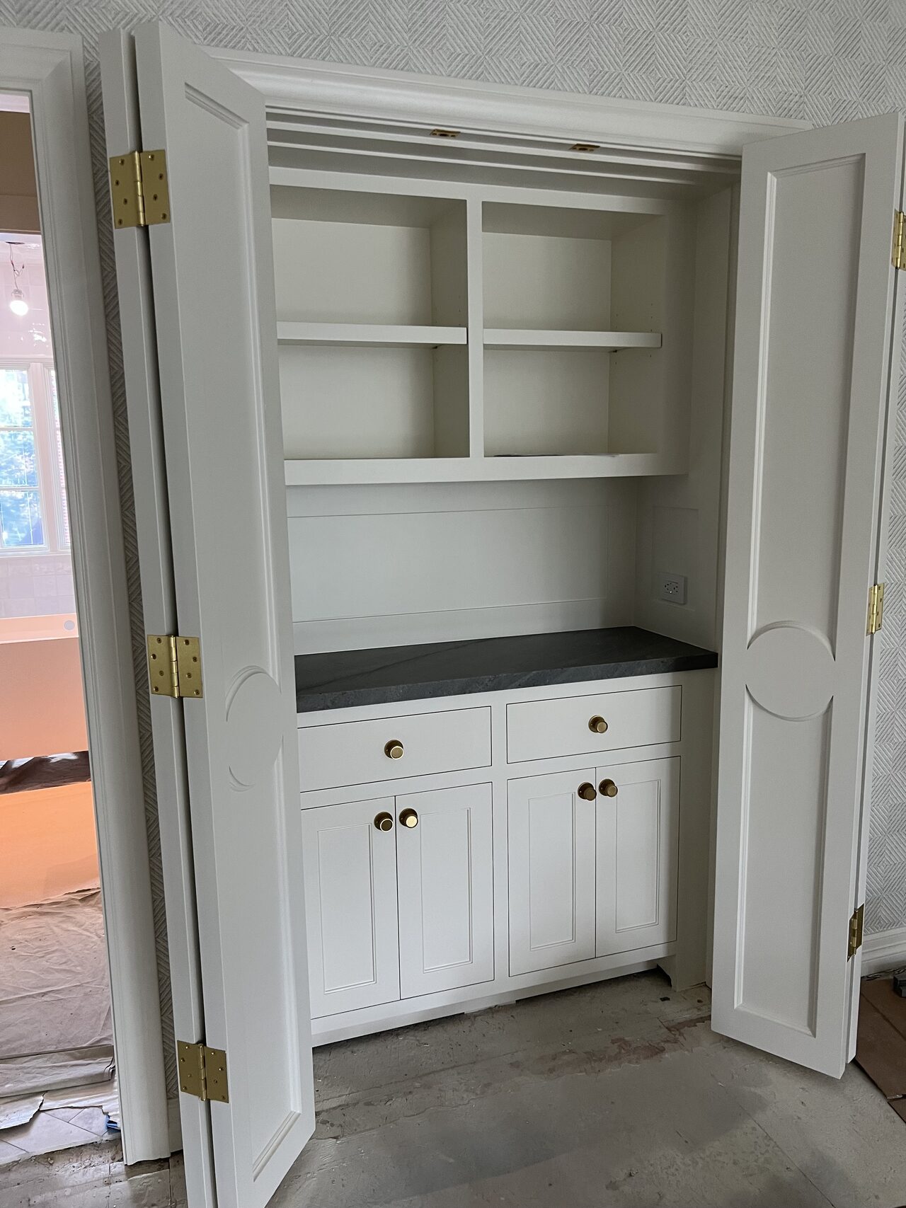 Finished white built-in niche with shelves, drawers, and lower doors inside the room opening for a Joel Hodge project.