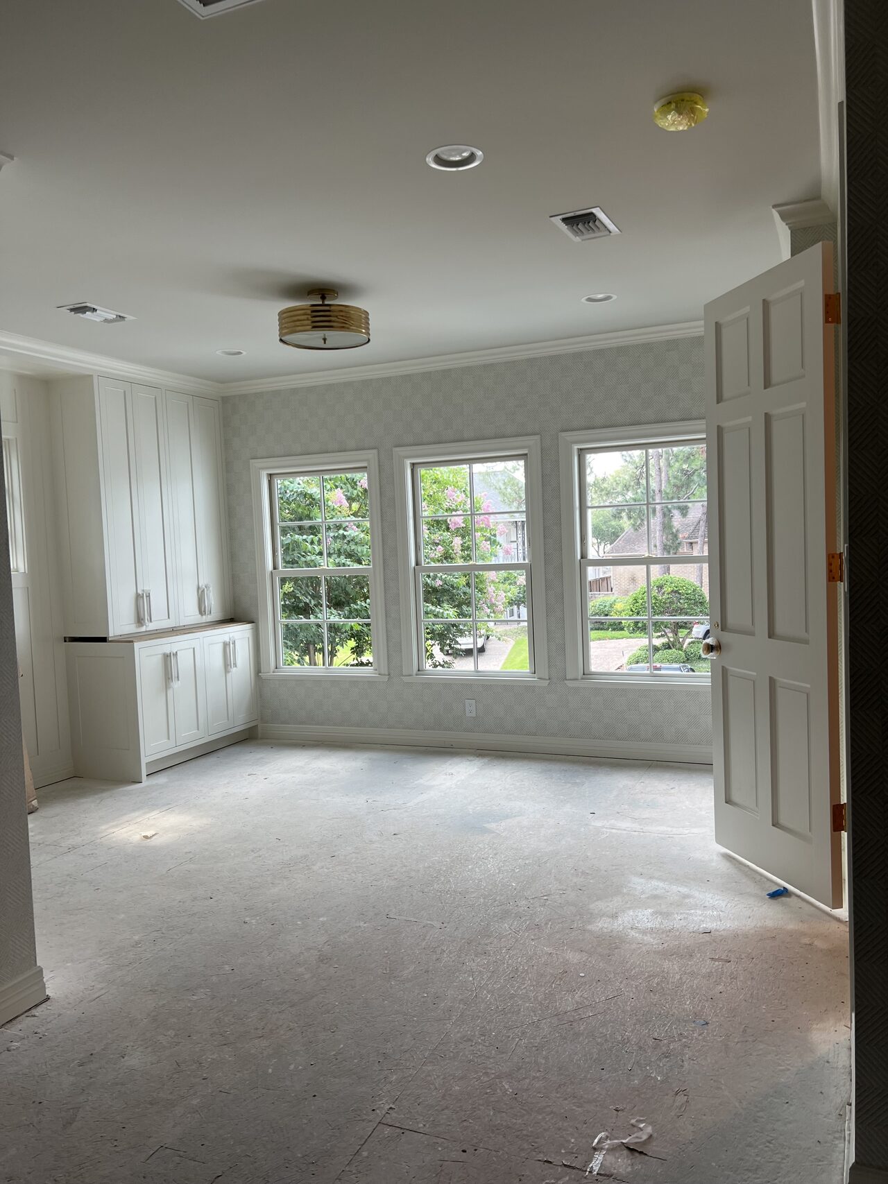 Large room view with window wall cabinetry after installation and before final room setup for a Joel Hodge project.
