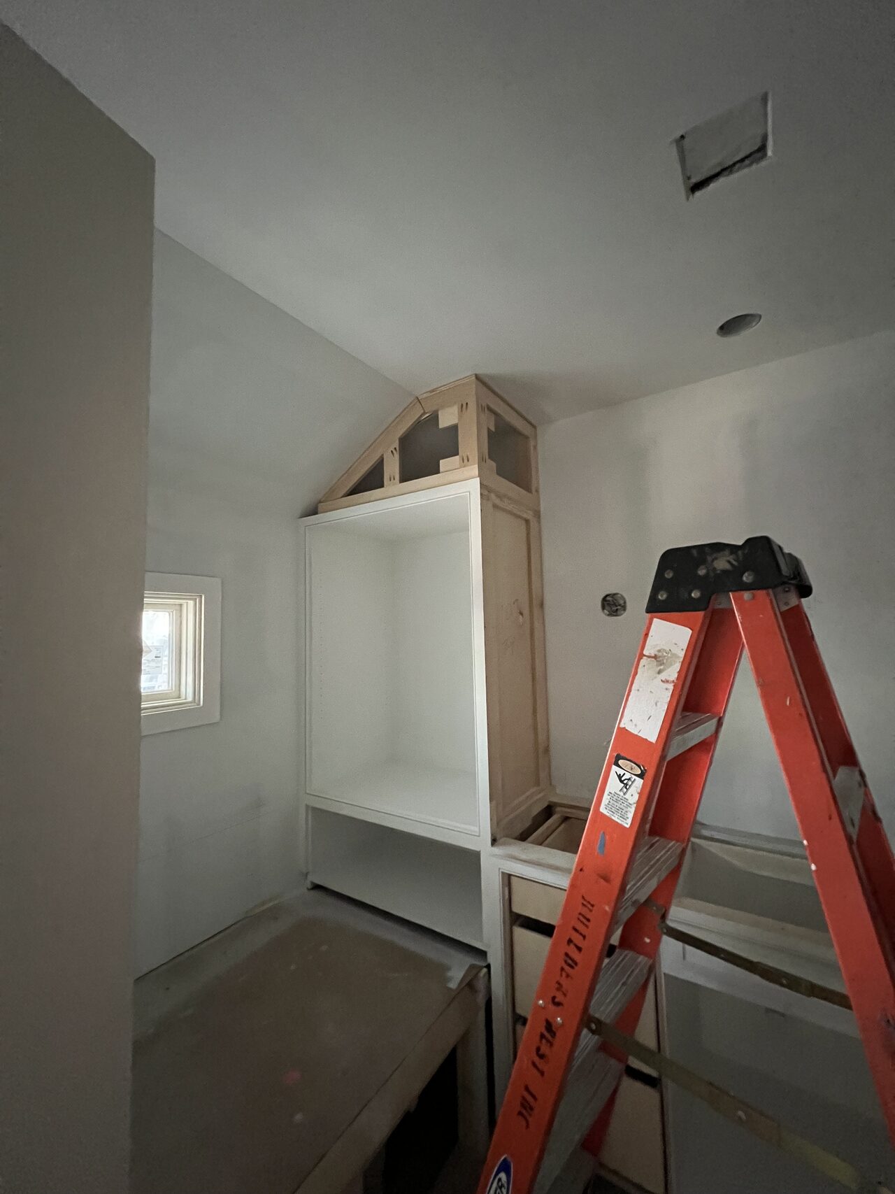 Tall wall niche opening prepared for custom cabinet and trim fitting for a Joel Hodge project.